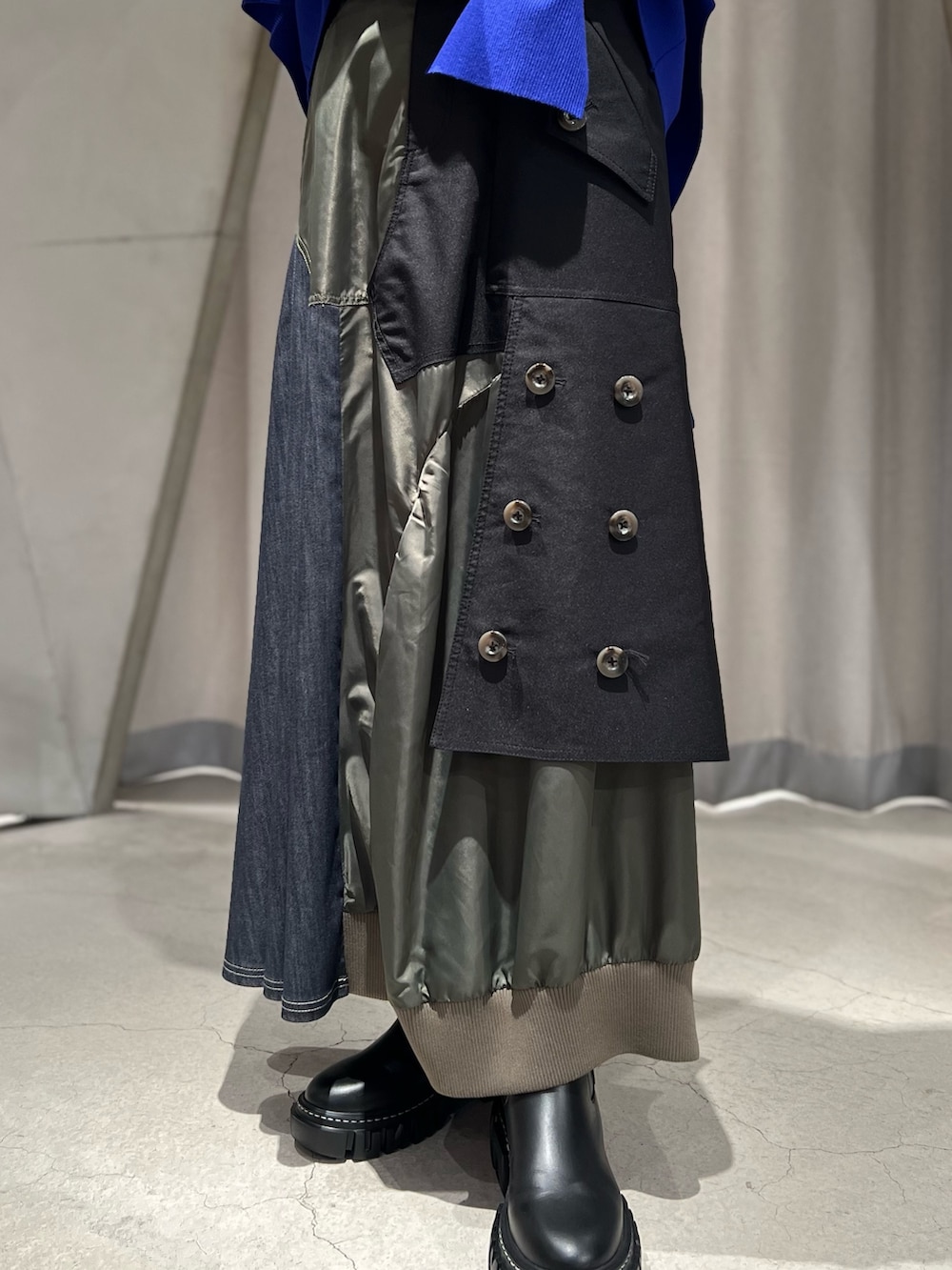 ブルー系のニット/セーター、ブラック系のスカート、ブラック系のブーツを着用したレディースの秋コーディネートの4枚目の写真