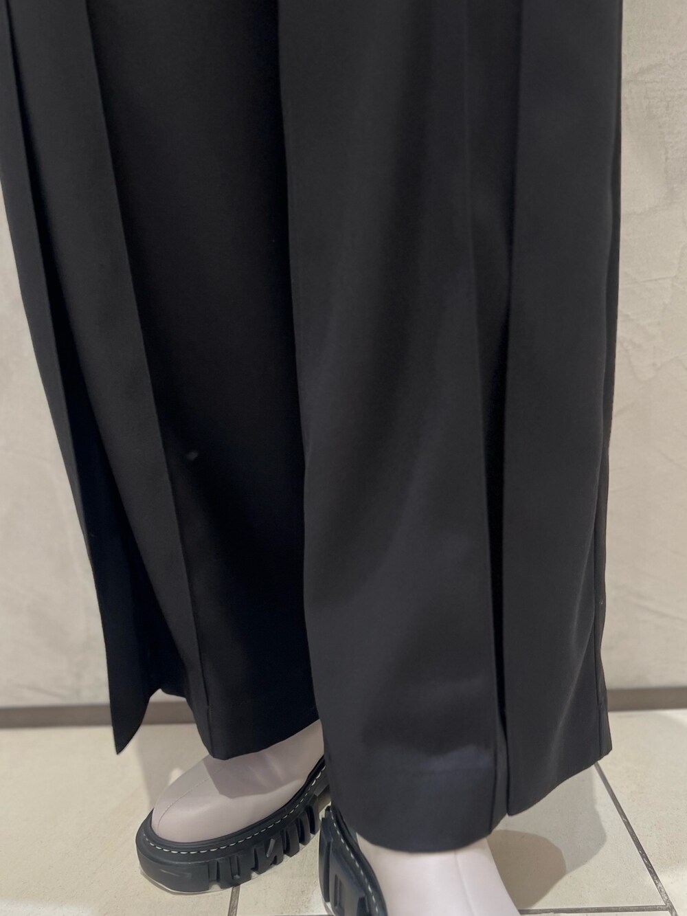 ブラック系のブルゾン、オレンジ系のニット/セーター、ブラック系のその他パンツを着用したレディースの秋コーディネートの6枚目の写真