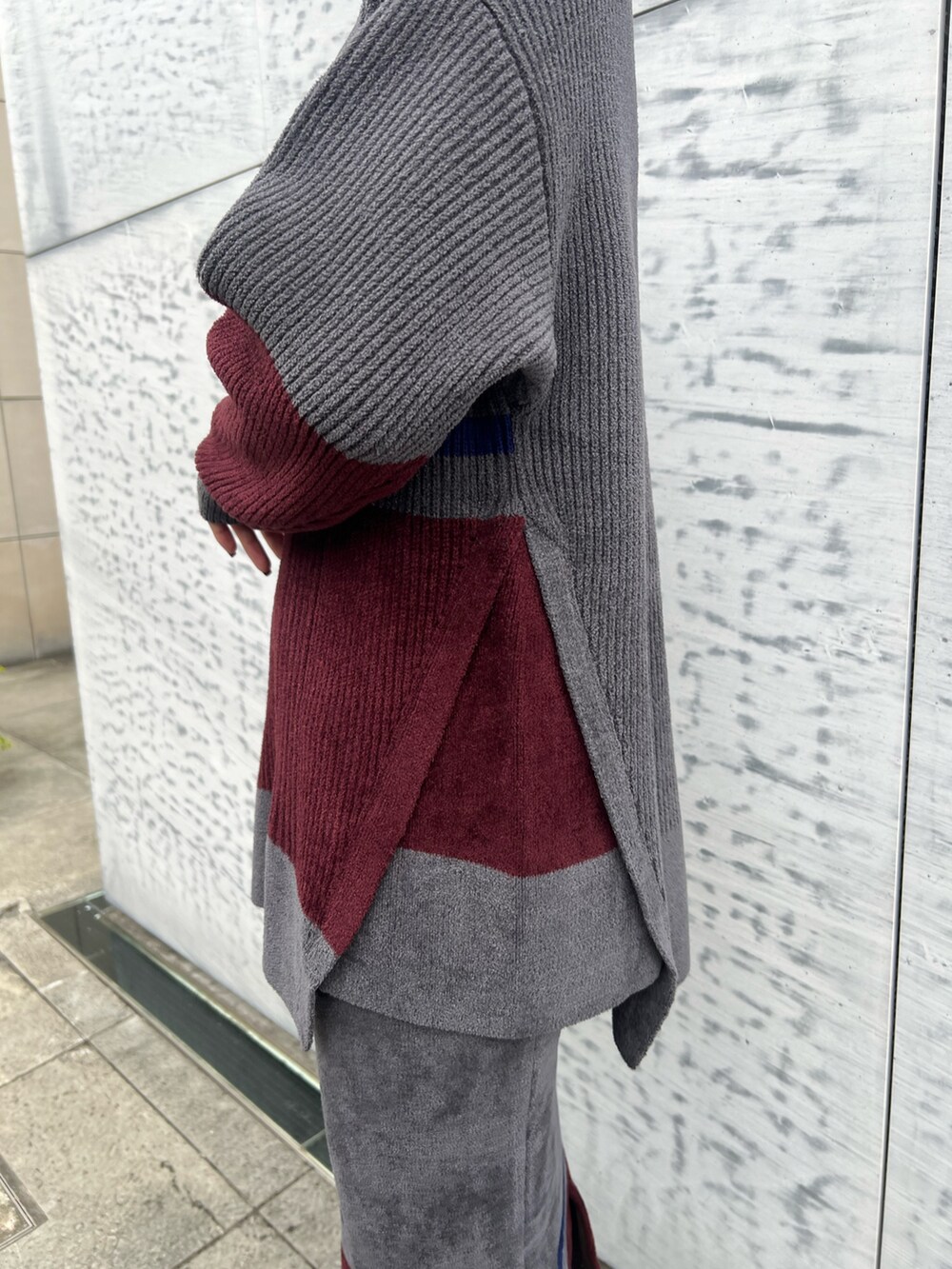 グレー系のニット/セーター、グレー系のスカート、ブラック系のブーツを着用したレディースの冬コーディネートの5枚目の写真