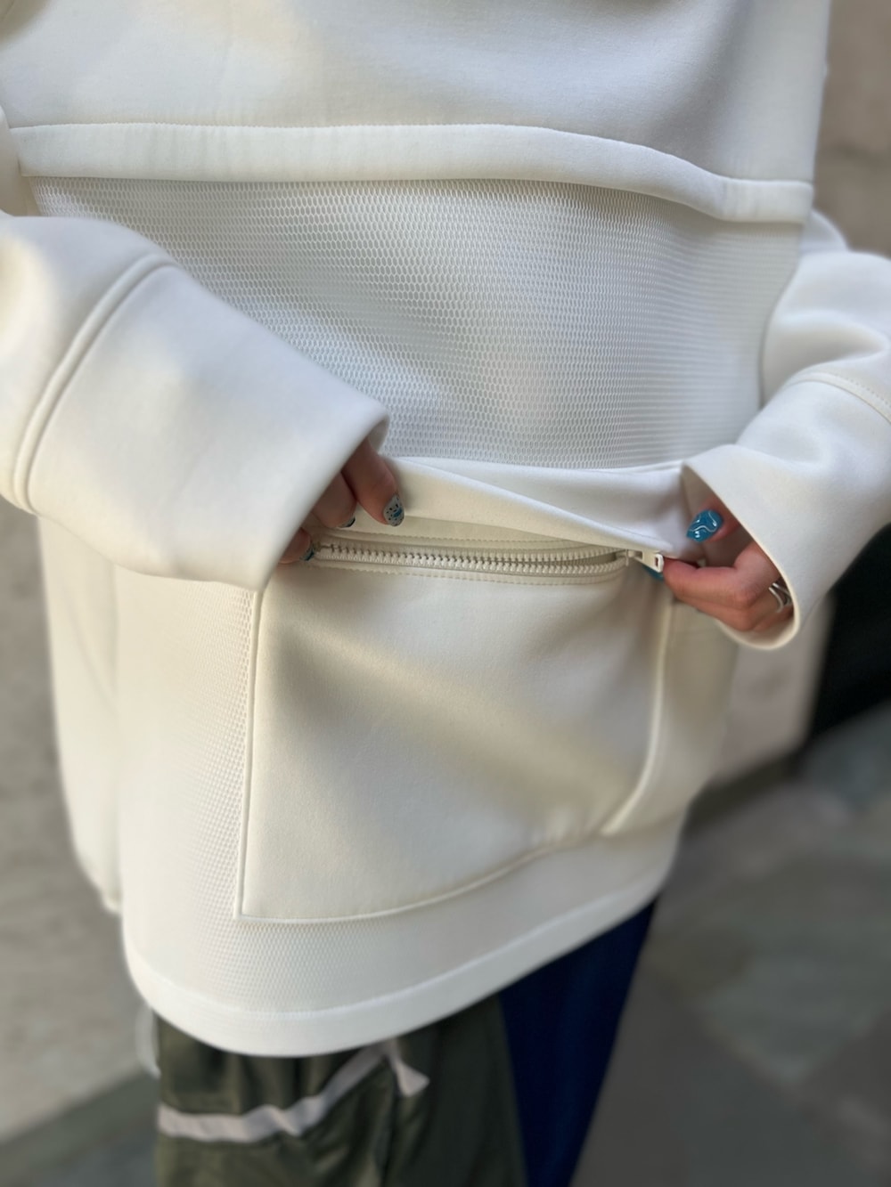 ブラック系のスカート、ホワイト系のスウェット、ブラック系のブーツを着用したレディースの秋コーディネートの6枚目の写真