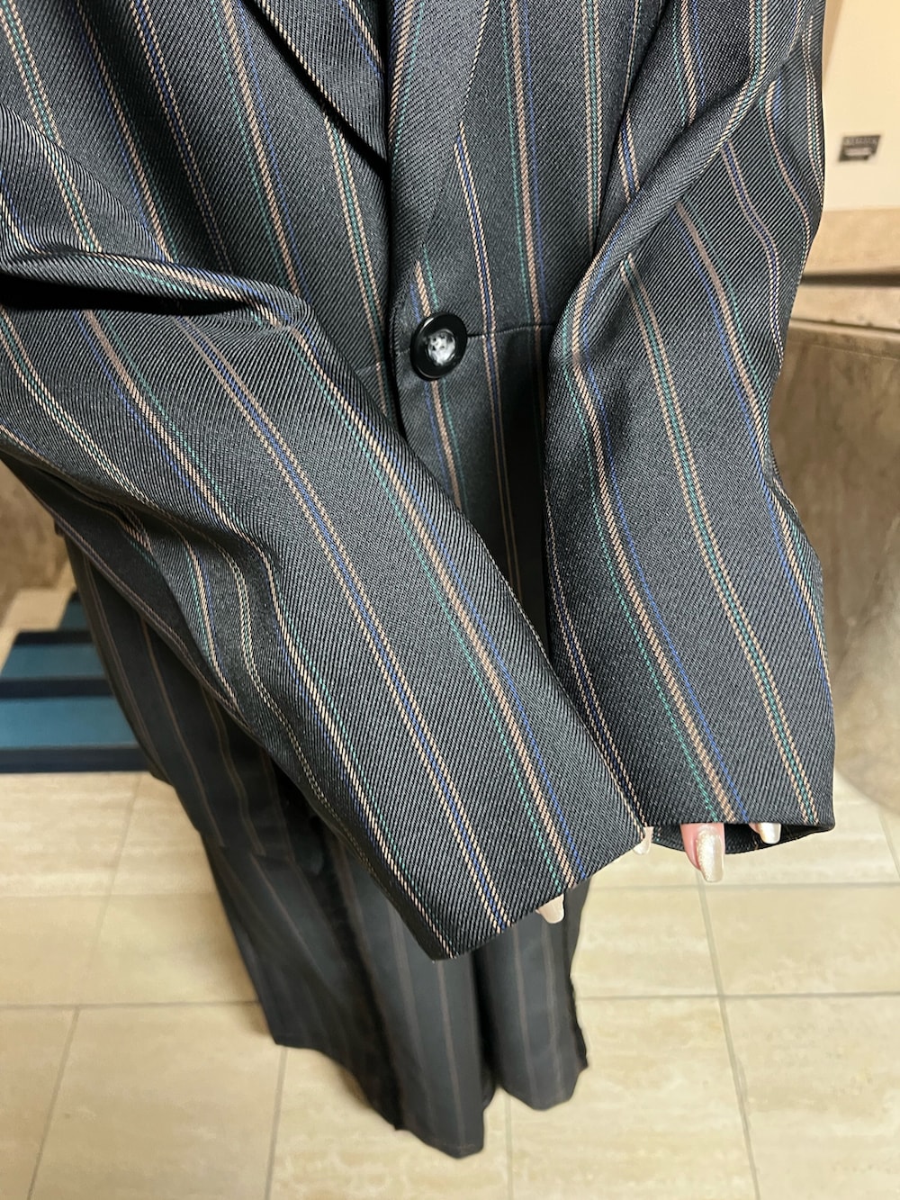 ブラック系のテーラードジャケット、ブラック系のブーツ、ブラック系のスラックスを着用したレディースの冬コーディネートの6枚目の写真