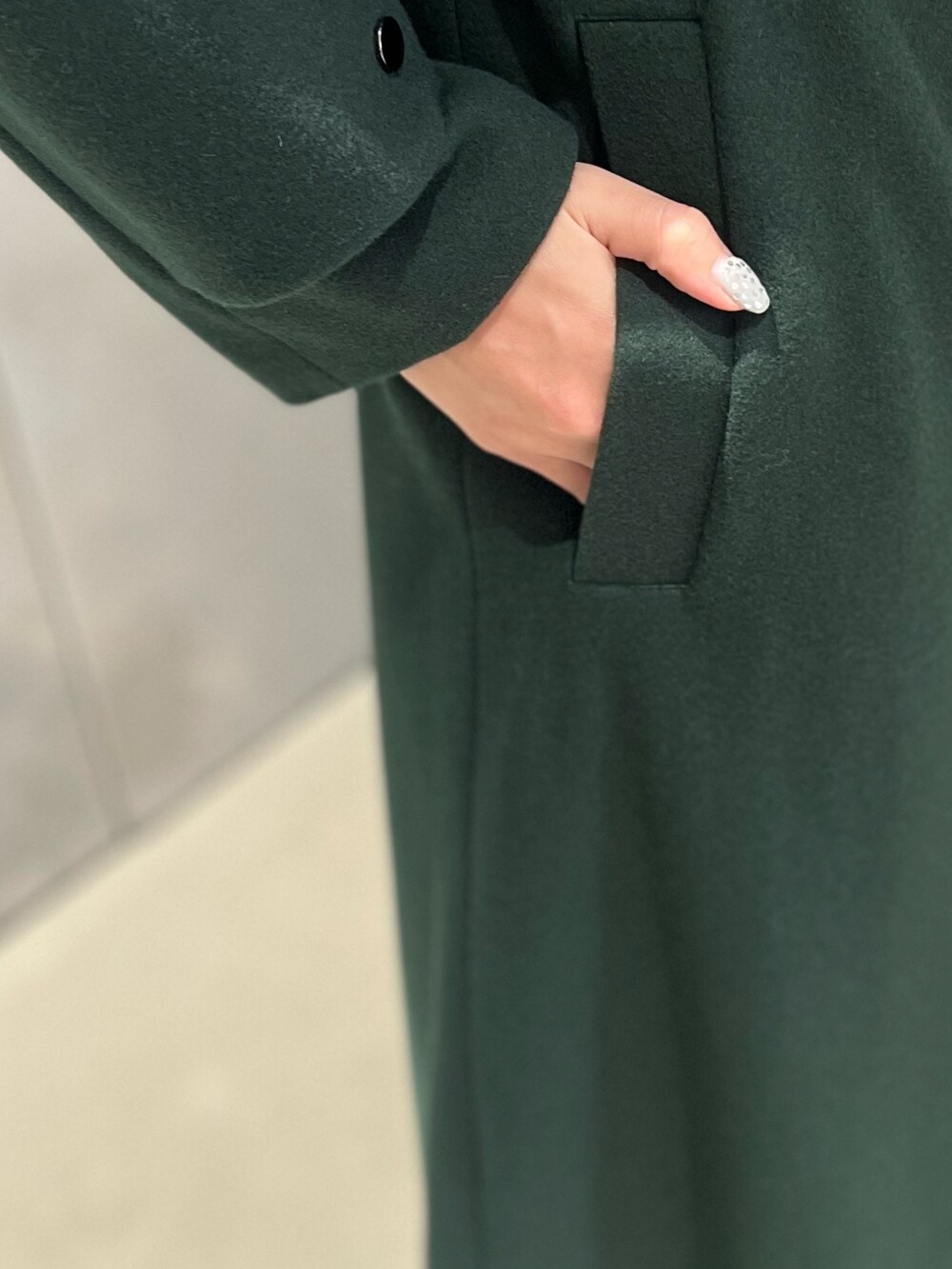 グリーン系のダウンベスト、グリーン系のその他アウター、シルバー系のイヤリングを着用したレディースの秋コーディネートの6枚目の写真