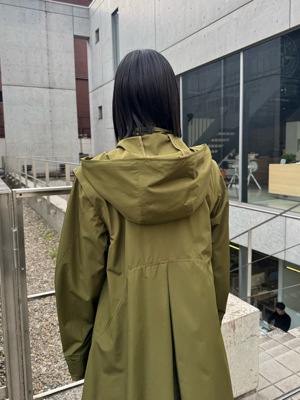 グリーン系のその他アウター、ブラック系のブーツを着用したレディースの冬コーディネートの5枚目の写真