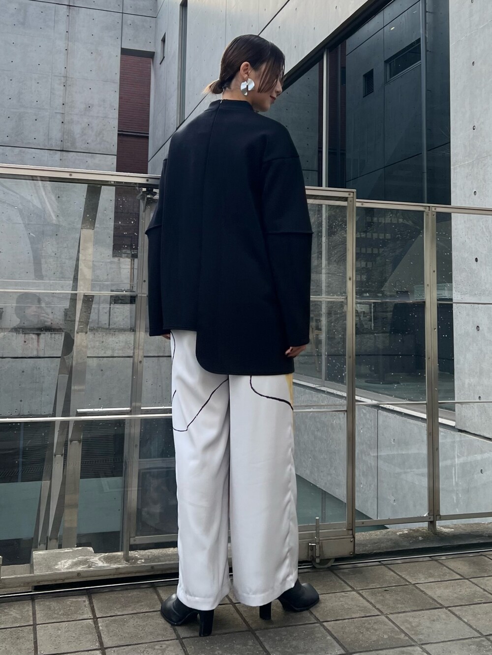 ホワイト系のその他パンツ、ブラック系のTシャツ/カットソー、ブラック系のブーツを着用したレディースの冬コーディネートの3枚目の写真