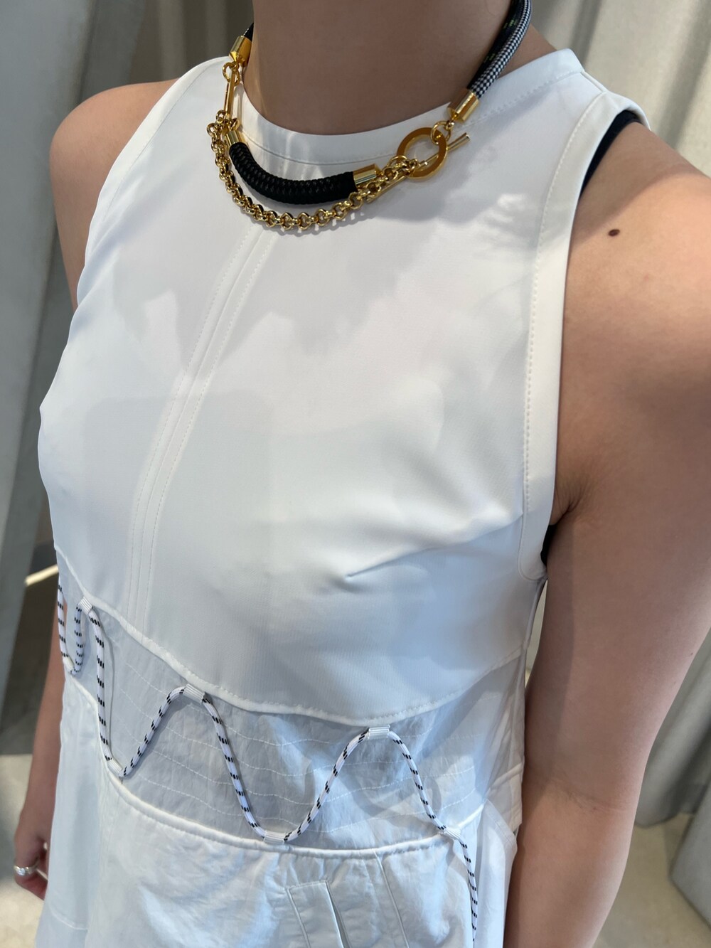 ホワイト系のタンクトップ、ホワイト系のスカート、ブラック系のサンダルを着用したレディースの冬コーディネートの4枚目の写真