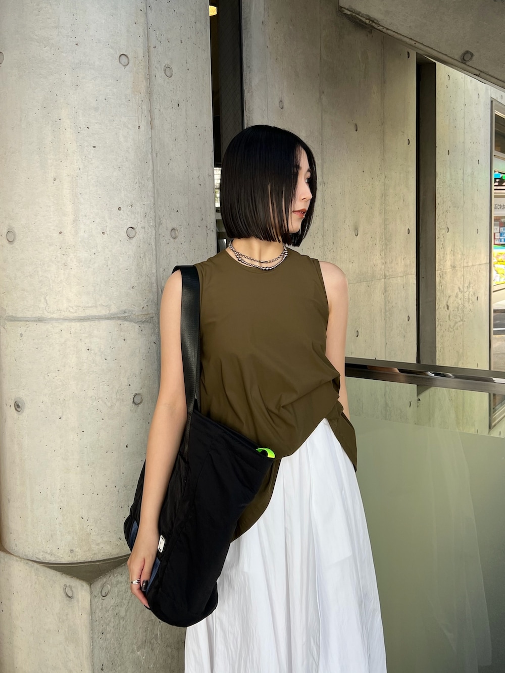 ホワイト系のワンピース、ブラック系のトートバッグ、シルバー系のサンダルを着用したレディースの春コーディネートの3枚目の写真