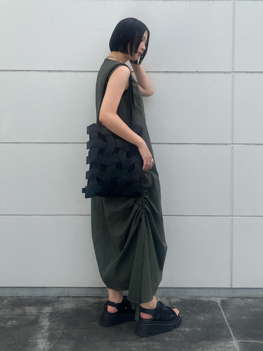 グリーン系のワンピース、ブラック系のトートバッグ、ブラック系のサンダルを着用したレディースの夏コーディネートの3枚目の写真