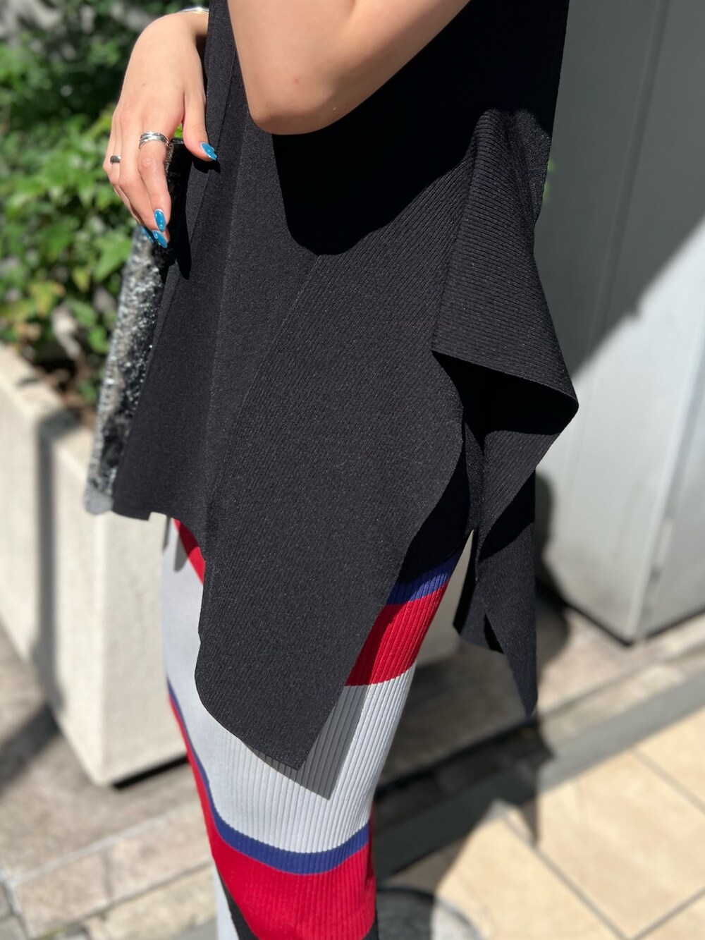 ブラック系のニット/セーター、ブラック系のスカート、シルバー系のトートバッグを着用したレディースの夏コーディネートの8枚目の写真