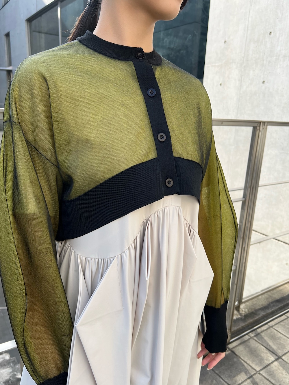 イエロー系のカーディガン/ボレロ、ベージュ系のワンピース、ブラック系のブーツを着用したレディースの冬コーディネートの4枚目の写真