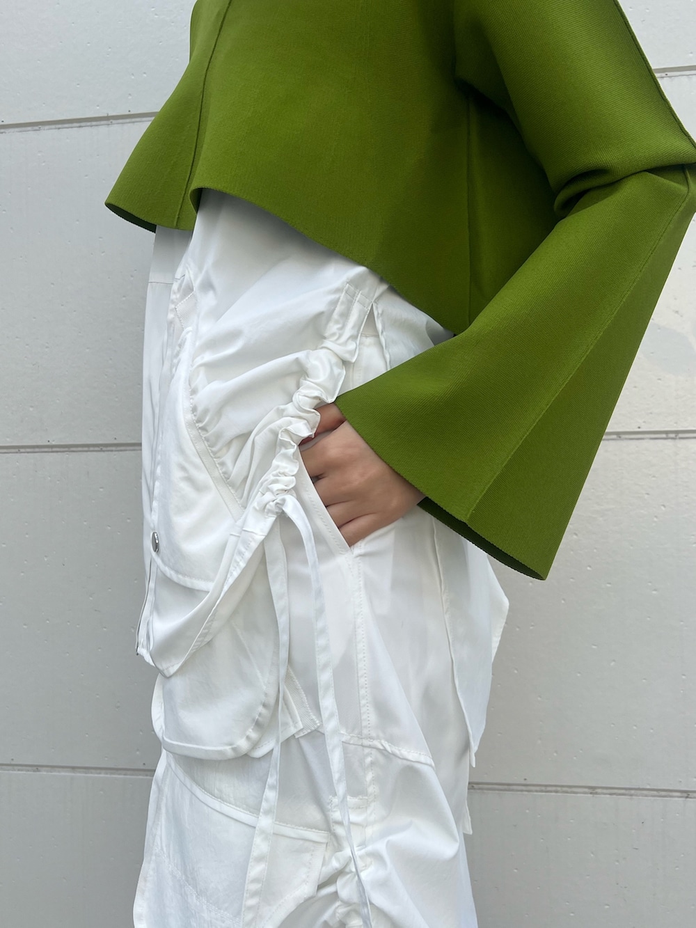 ホワイト系のスカート、グリーン系のニット/セーター、ブラック系のショルダーバッグを着用したレディースの冬コーディネートの6枚目の写真