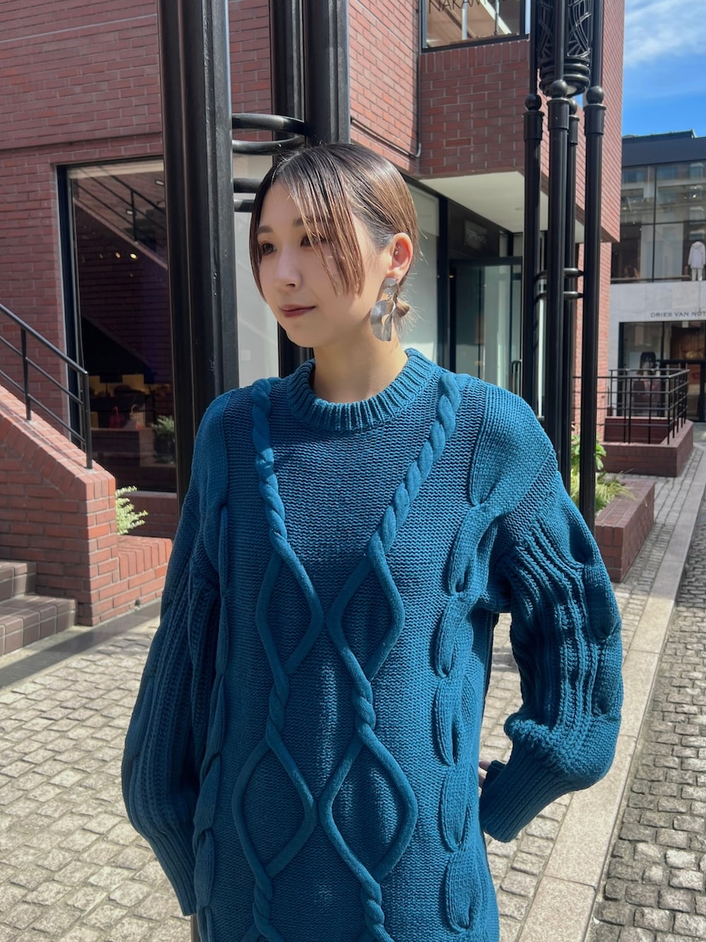 ブルー系のワンピース、ブラック系のブーツ、シルバー系のイヤリングを着用したレディースの秋コーディネートの3枚目の写真