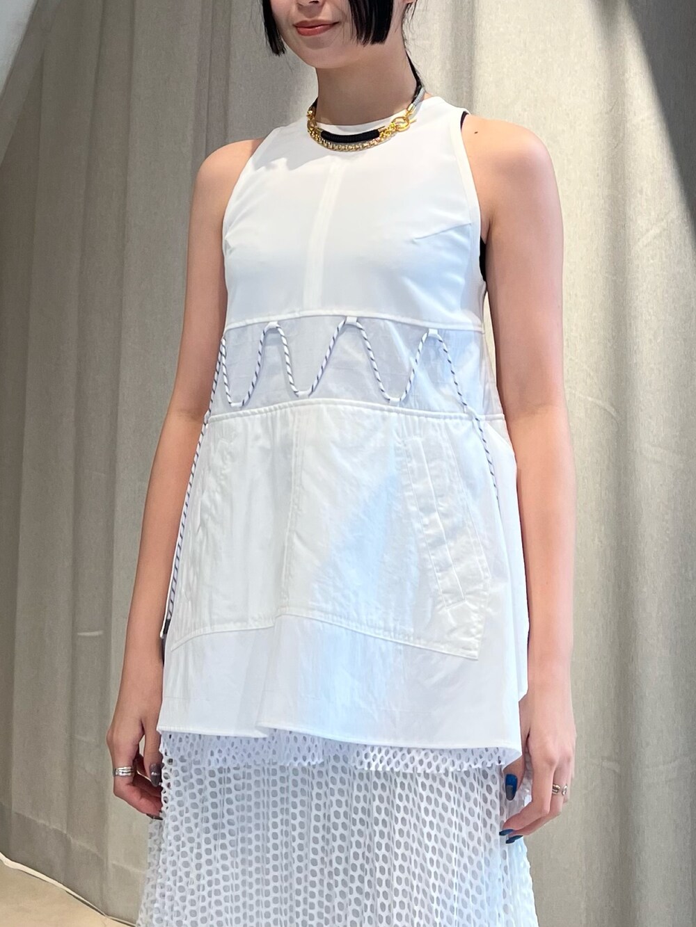 ホワイト系のタンクトップ、ホワイト系のスカート、ブラック系のサンダルを着用したレディースの冬コーディネートの3枚目の写真