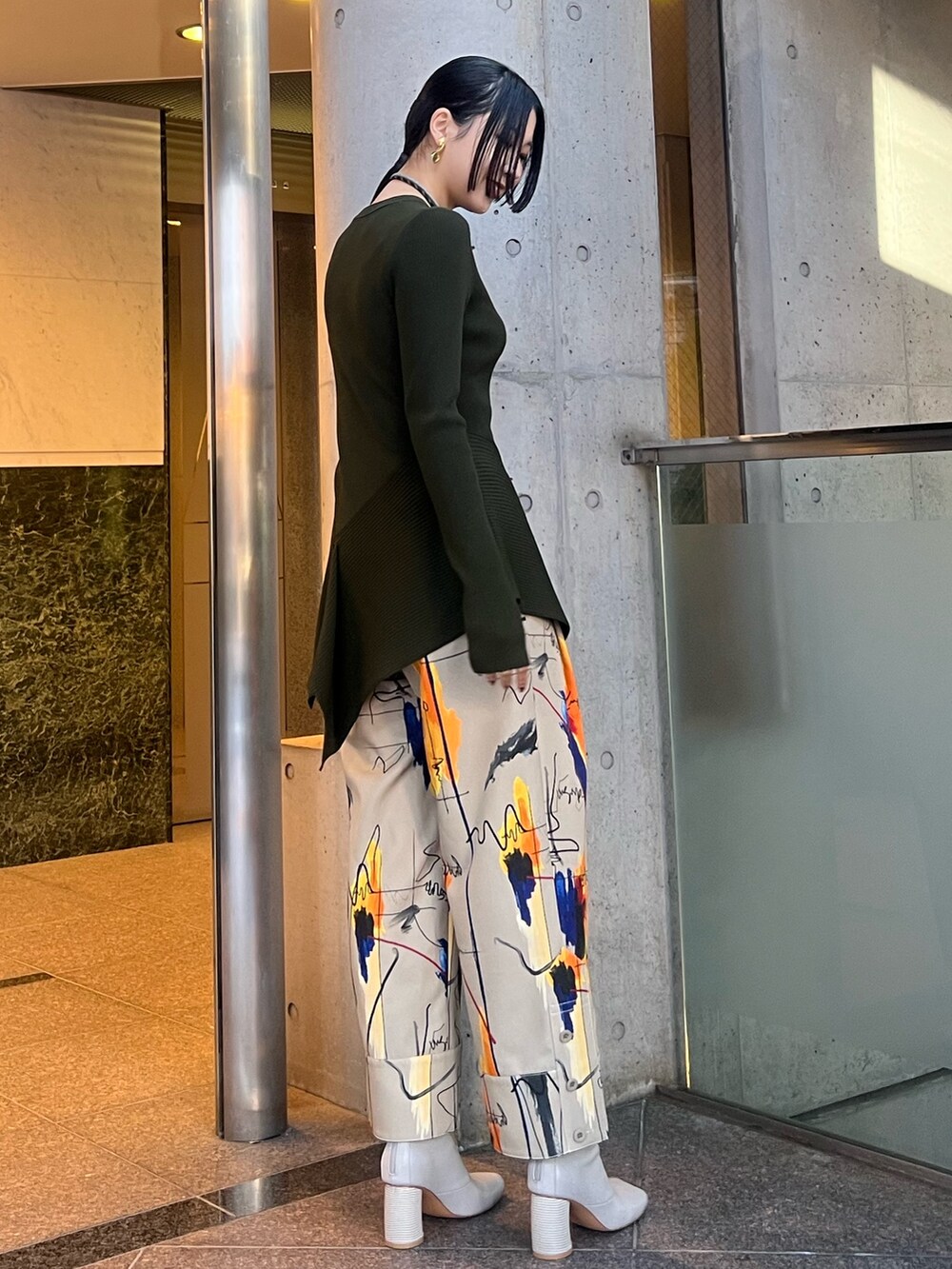グリーン系のニット/セーター、ベージュ系のその他パンツ、ベージュ系のブーツを着用したレディースの冬コーディネートの3枚目の写真