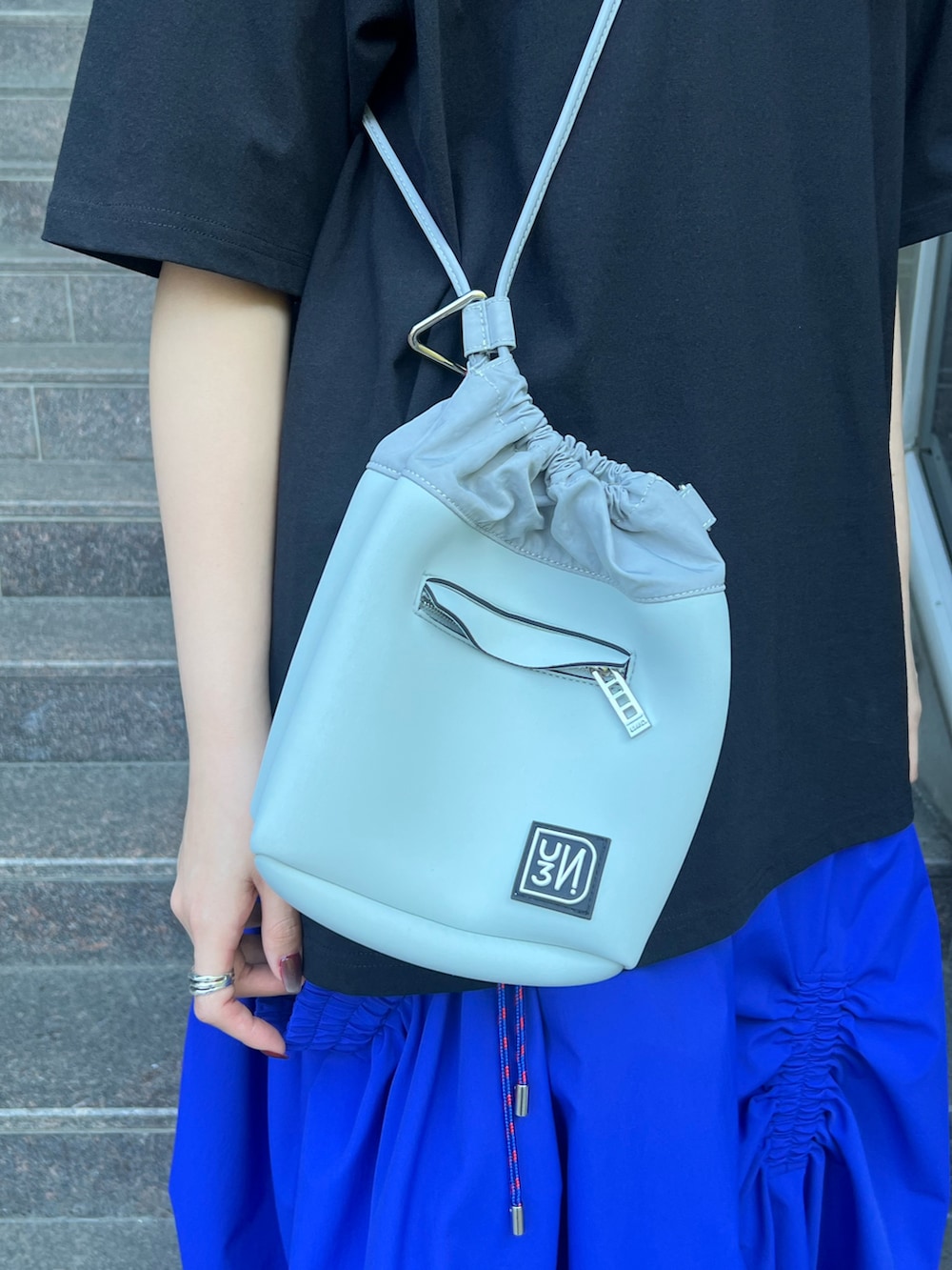 ブラック系のTシャツ/カットソー、ブルー系のスカート、グレー系のショルダーバッグを着用したレディースの夏コーディネートの6枚目の写真