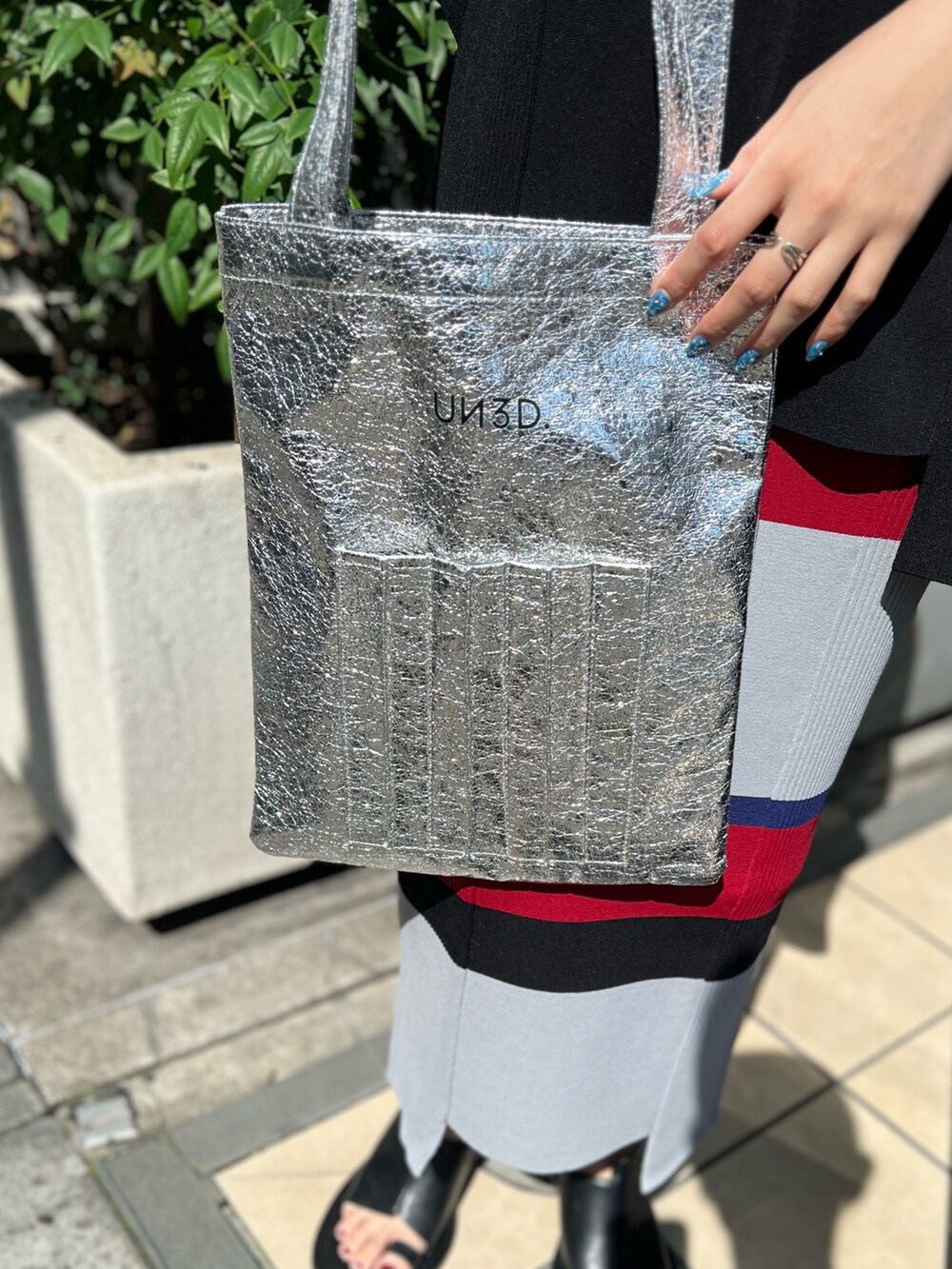 ブラック系のニット/セーター、ブラック系のスカート、シルバー系のトートバッグを着用したレディースの夏コーディネートの5枚目の写真