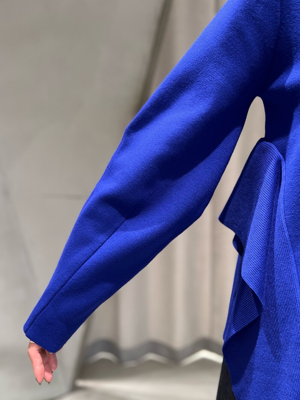 ブルー系のニット/セーター、ブラック系のスカート、ブラック系のブーツを着用したレディースの秋コーディネートの6枚目の写真