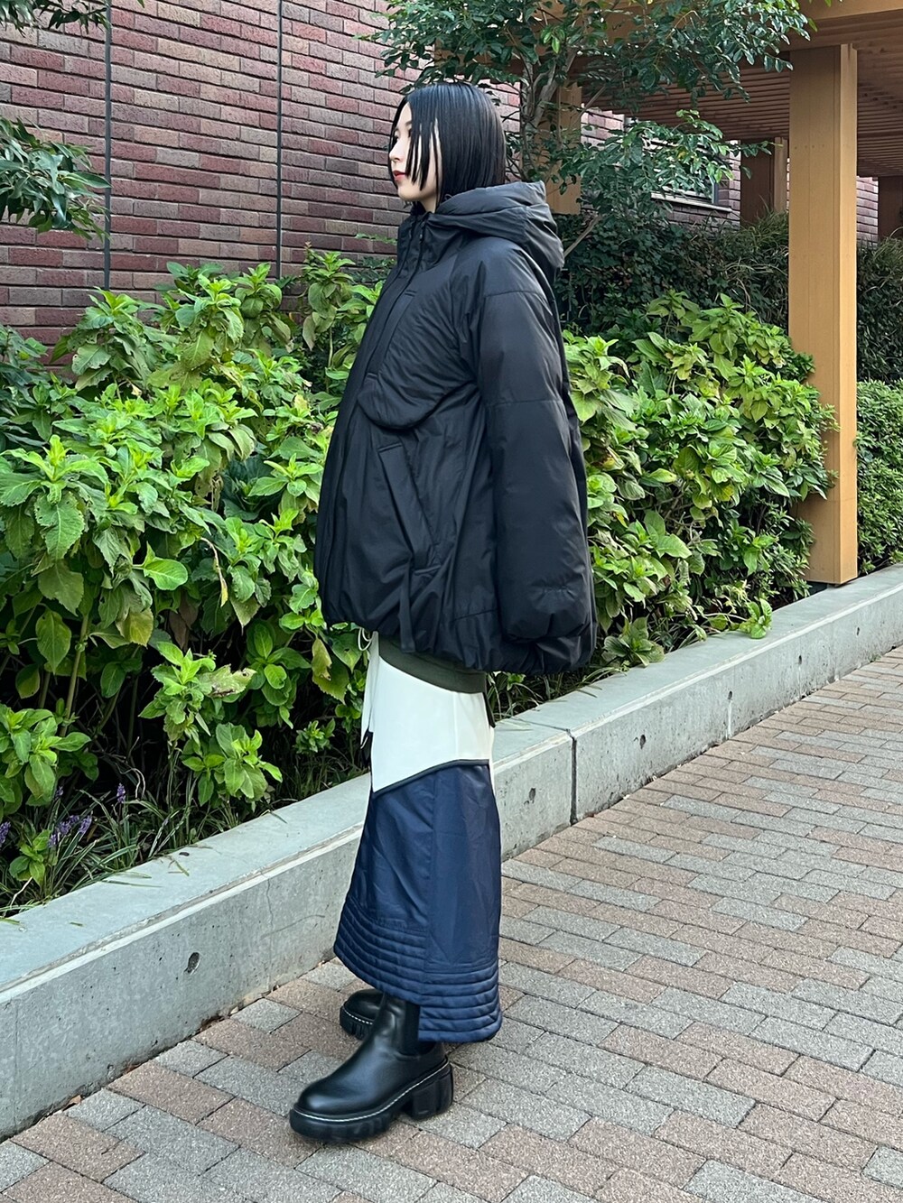 ブラック系のダウンジャケット/コート、その他のスカート、ブラック系のブーツを着用したレディースの秋コーディネートの3枚目の写真