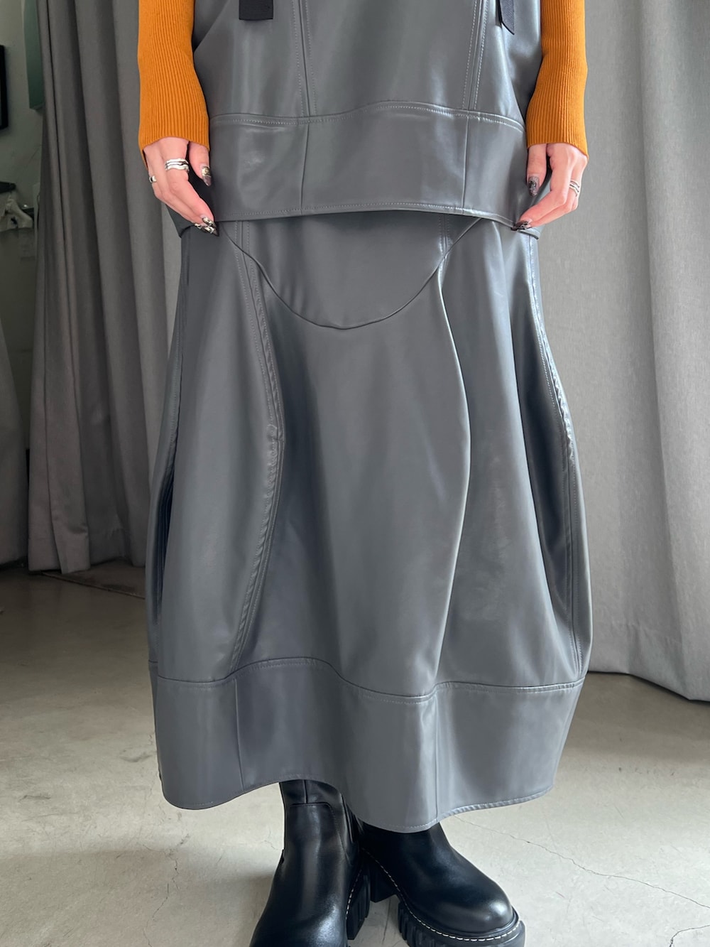 グレー系のその他トップス、グレー系のスカート、ブラック系のブーツを着用したレディースの秋コーディネートの6枚目の写真