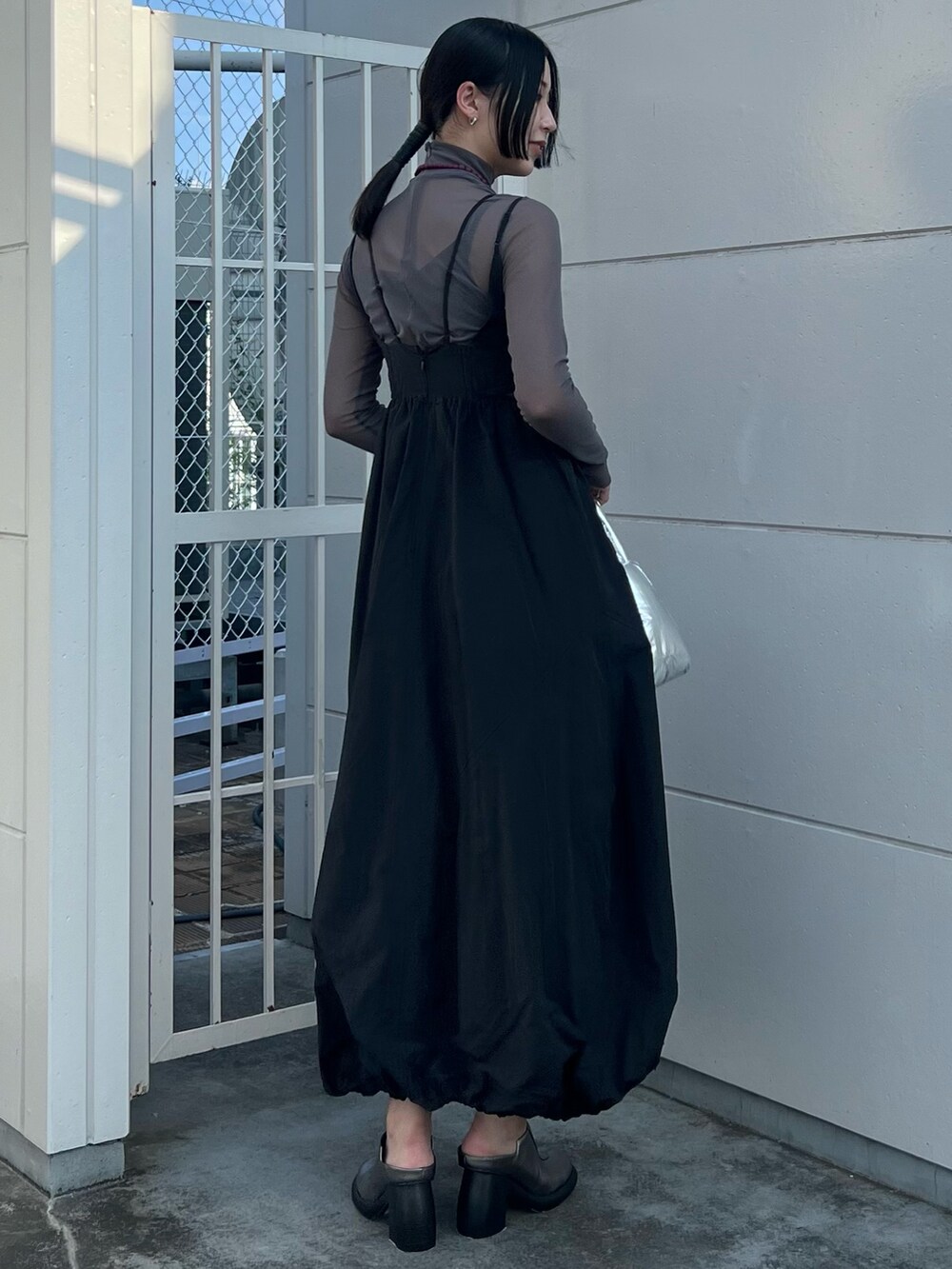 ブラック系のワンピース、グレー系のTシャツ/カットソー、シルバー系のハンドバッグを着用したレディースの夏コーディネートの2枚目の写真