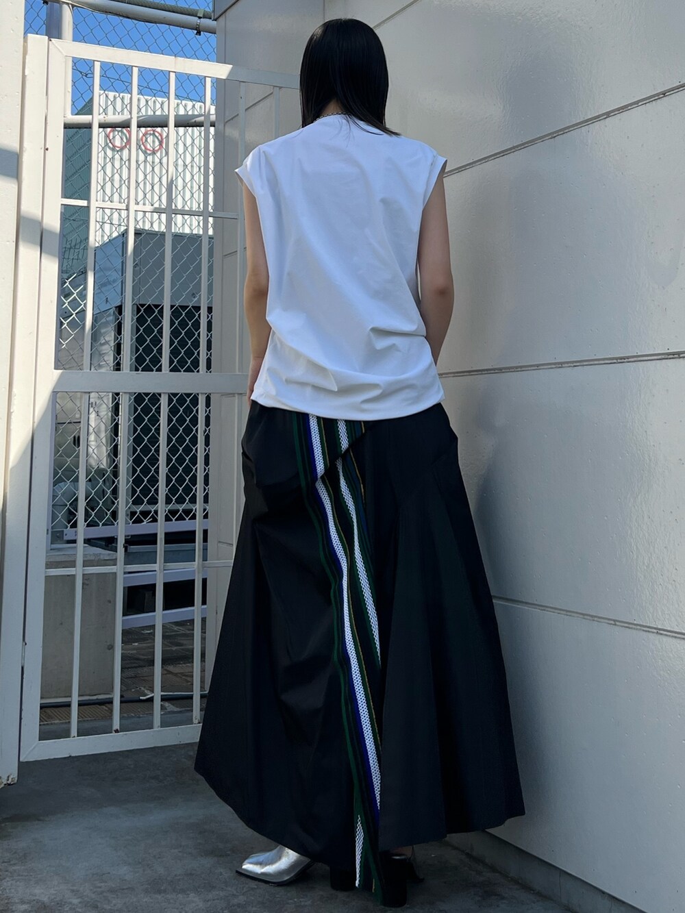 ホワイト系のTシャツ/カットソー、グリーン系のスカート、シルバー系のパンプスを着用したレディースの夏コーディネートの3枚目の写真