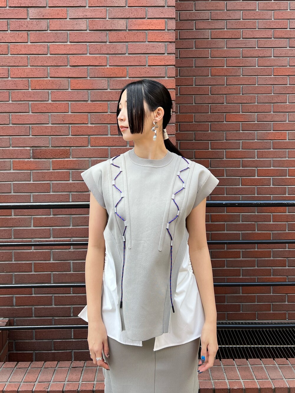 ベージュ系のニット/セーター、ベージュ系のスカート、ベージュ系のサンダルを着用したレディースの春コーディネートの3枚目の写真