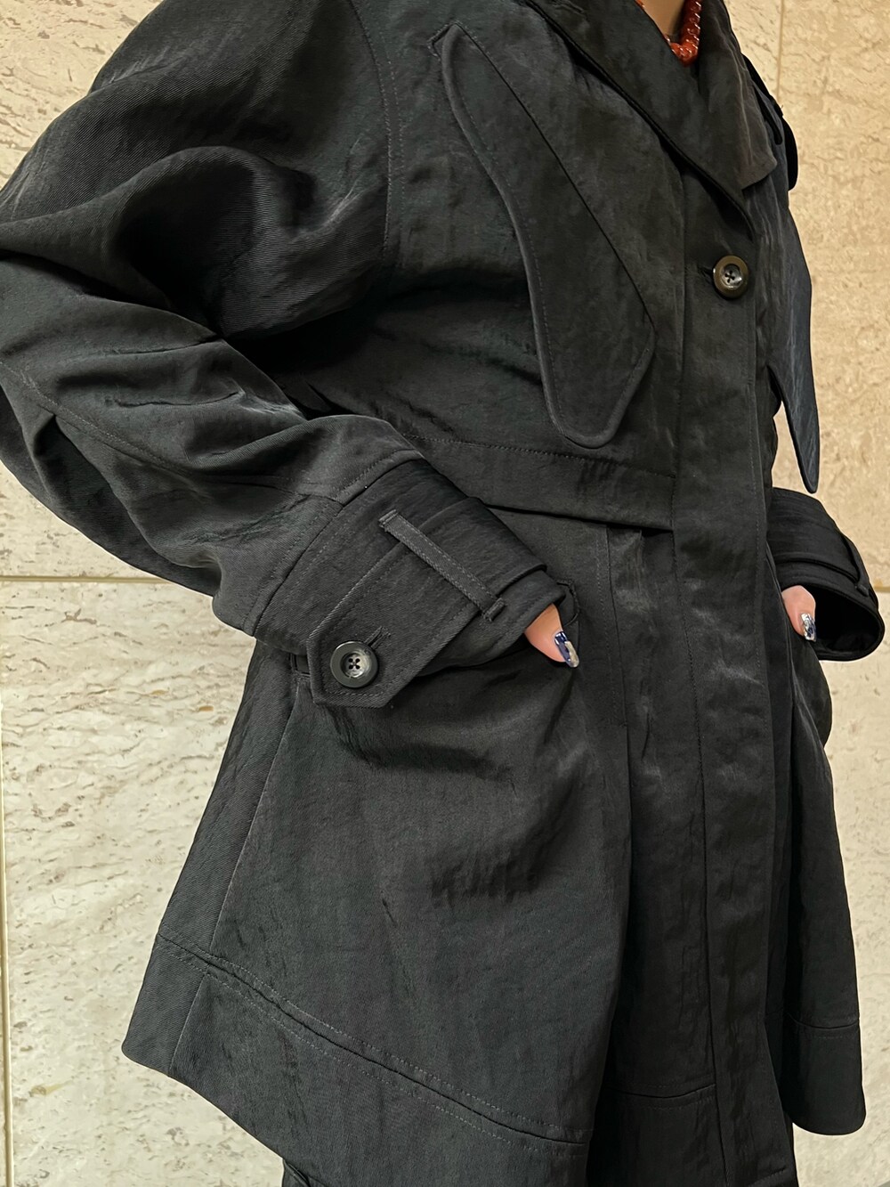 ブラック系のミリタリージャケット、ブラック系のスカート、その他のブーツを着用したレディースの夏コーディネートの6枚目の写真