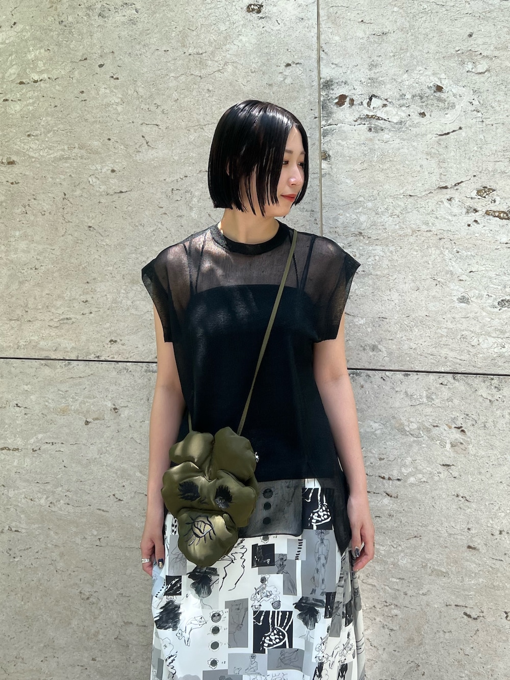 ブラック系のニット/セーター、その他のスカート、ブラック系のショルダーバッグを着用したレディースの夏コーディネートの3枚目の写真