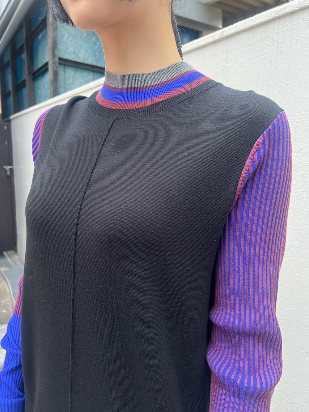 ブラック系のワンピース、シルバー系のハンドバッグ、ブラック系のブーツを着用したレディースの秋コーディネートの4枚目の写真