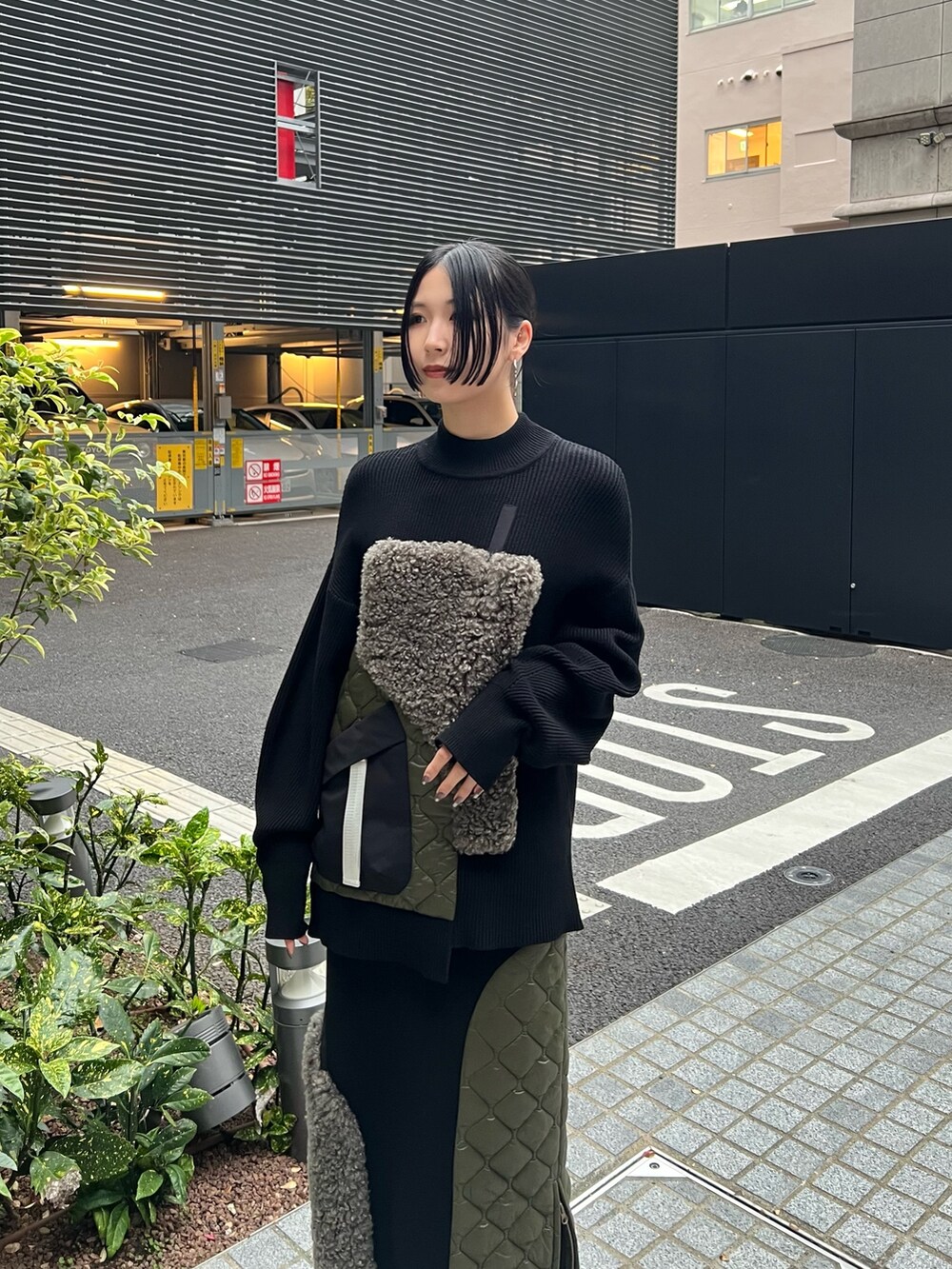 ブラック系のニット/セーター、ブラック系のスカート、ブラック系のブーツを着用したレディースの秋コーディネートの4枚目の写真