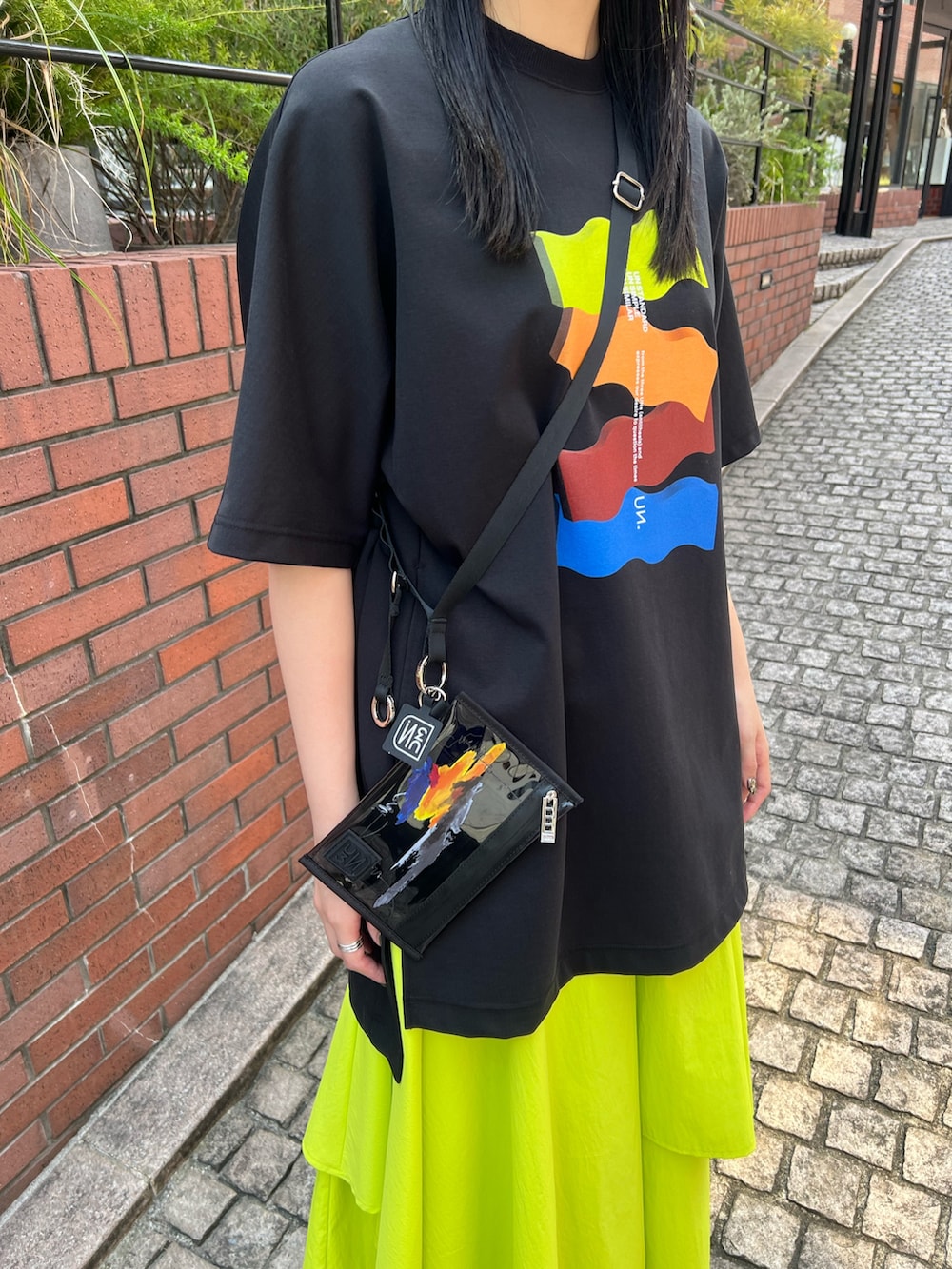 ブラック系のTシャツ/カットソー、イエロー系のその他パンツ、ブラック系のサンダルを着用したレディースの春コーディネートの5枚目の写真