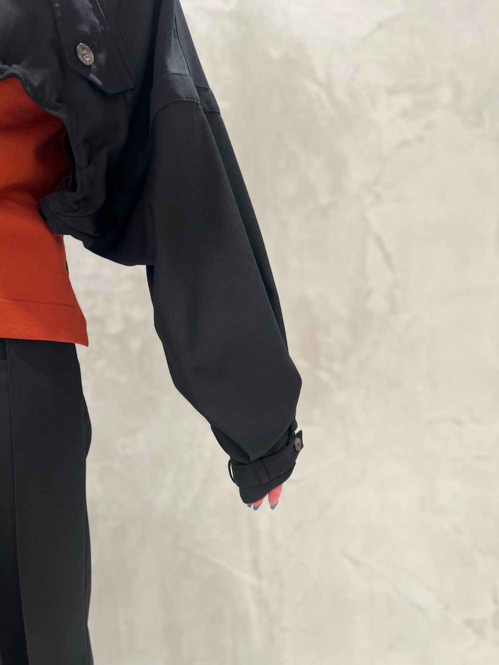 ブラック系のブルゾン、オレンジ系のニット/セーター、ブラック系のその他パンツを着用したレディースの秋コーディネートの5枚目の写真