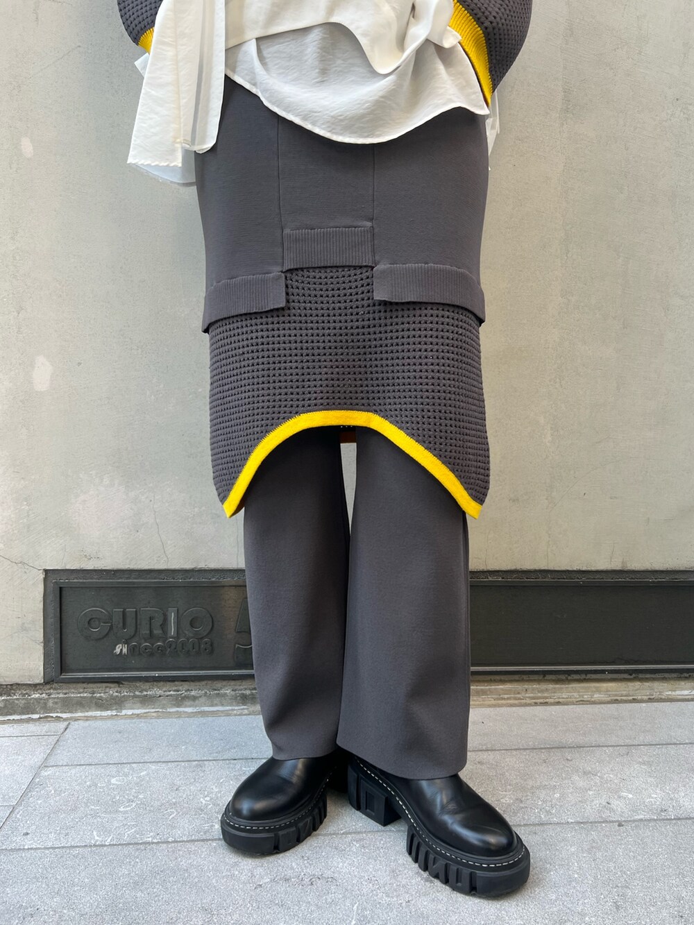 グレー系のその他パンツ、グレー系のニット/セーター、ホワイト系のシャツ/ブラウスを着用したレディースの夏コーディネートの7枚目の写真