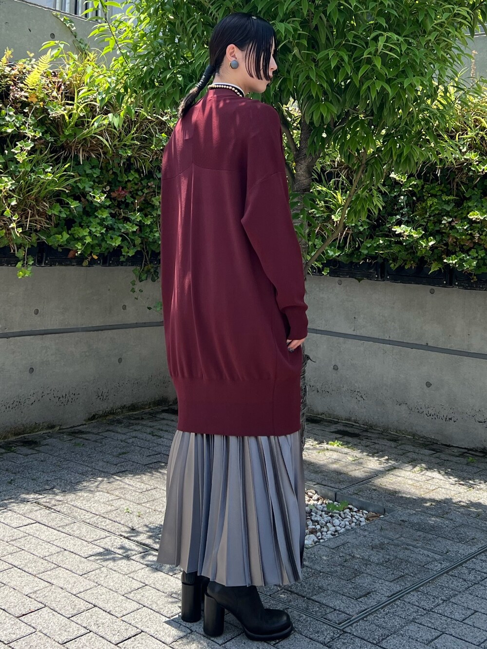 グレー系のスカート、ブラウン系のカーディガン/ボレロ、ブラック系のニット/セーターを着用したレディースの夏コーディネートの3枚目の写真