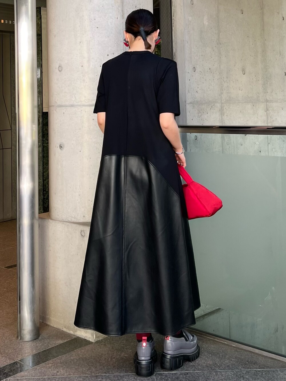 ブラック系のワンピース、グレー系のローファー、レッド系のハンドバッグを着用したレディースの夏コーディネートの2枚目の写真