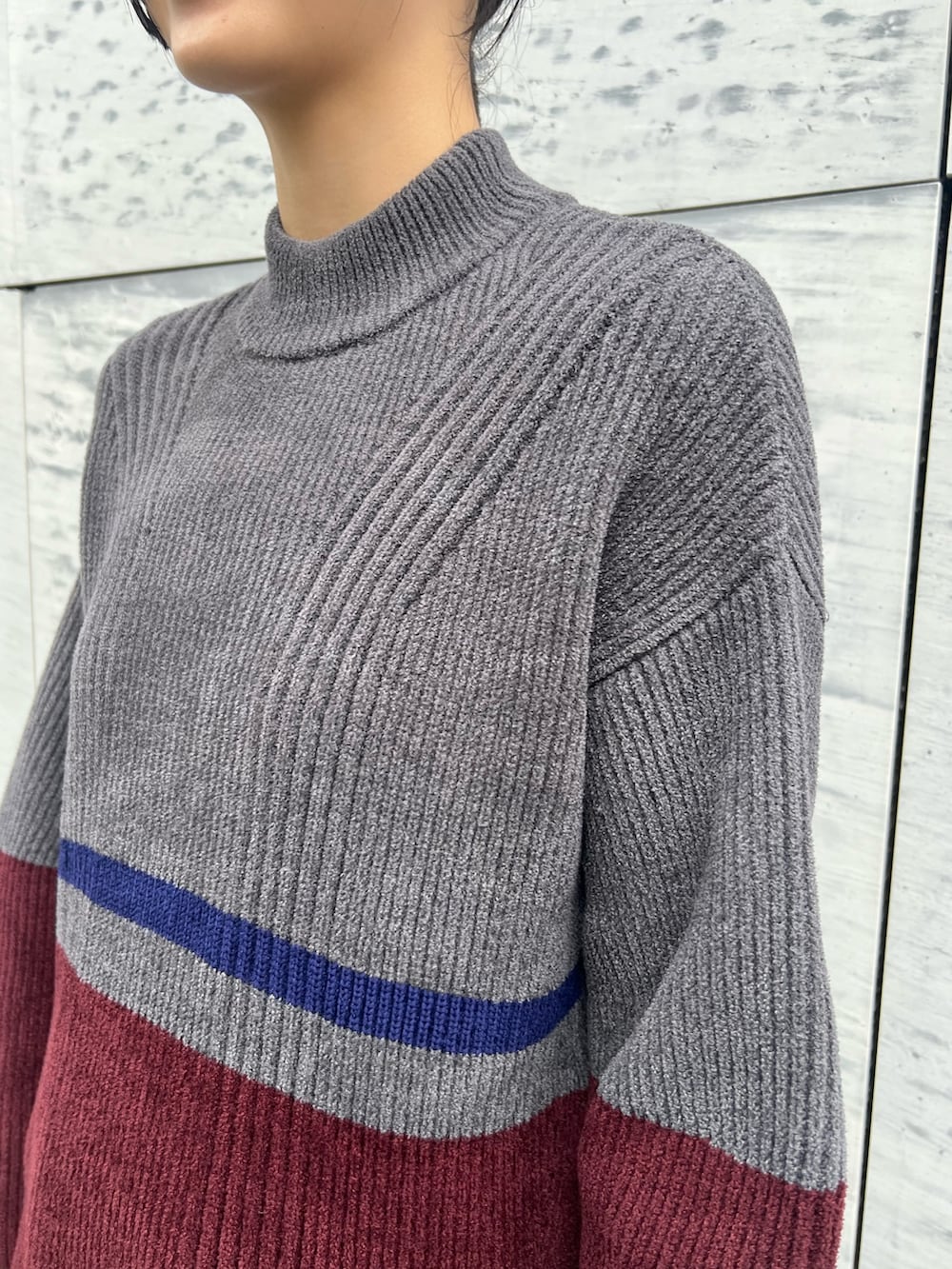 グレー系のニット/セーター、グレー系のスカート、ブラック系のブーツを着用したレディースの冬コーディネートの4枚目の写真