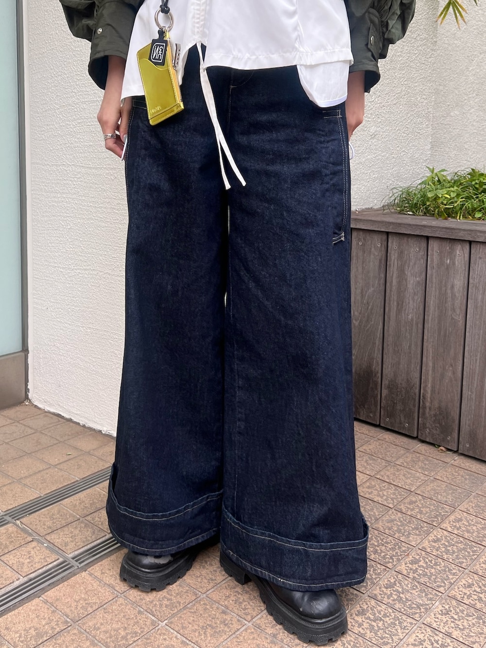 グリーン系のブルゾン、ホワイト系のTシャツ/カットソー、ブルー系のデニムパンツを着用したレディースの春コーディネートの6枚目の写真
