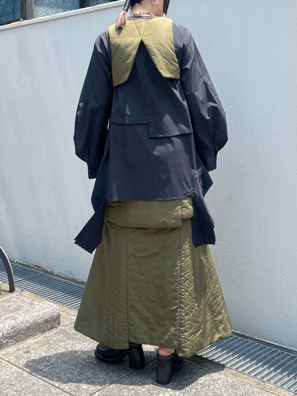 ベージュ系のスカート、ベージュ系のベスト、ブラック系のシャツ/ブラウスを着用したレディースの夏コーディネートの3枚目の写真
