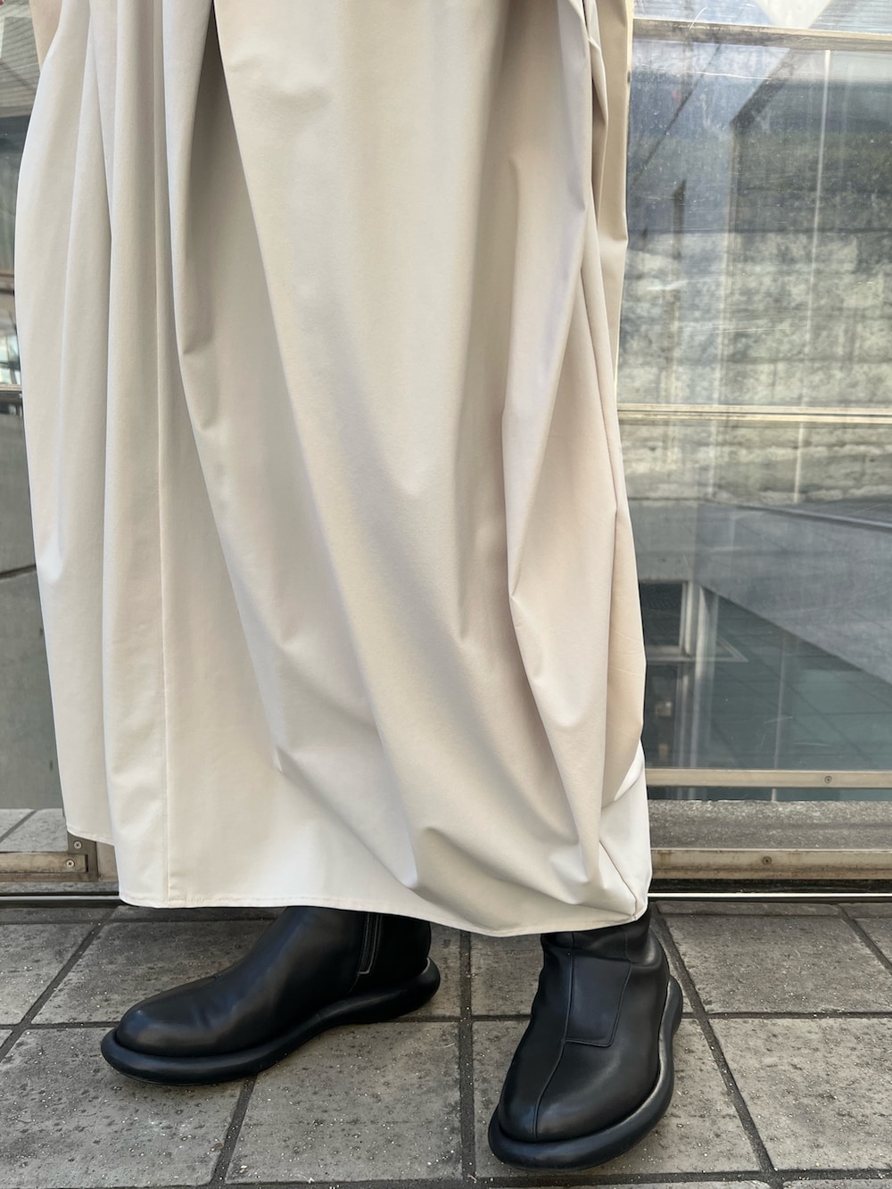 イエロー系のカーディガン/ボレロ、ベージュ系のワンピース、ブラック系のブーツを着用したレディースの冬コーディネートの6枚目の写真