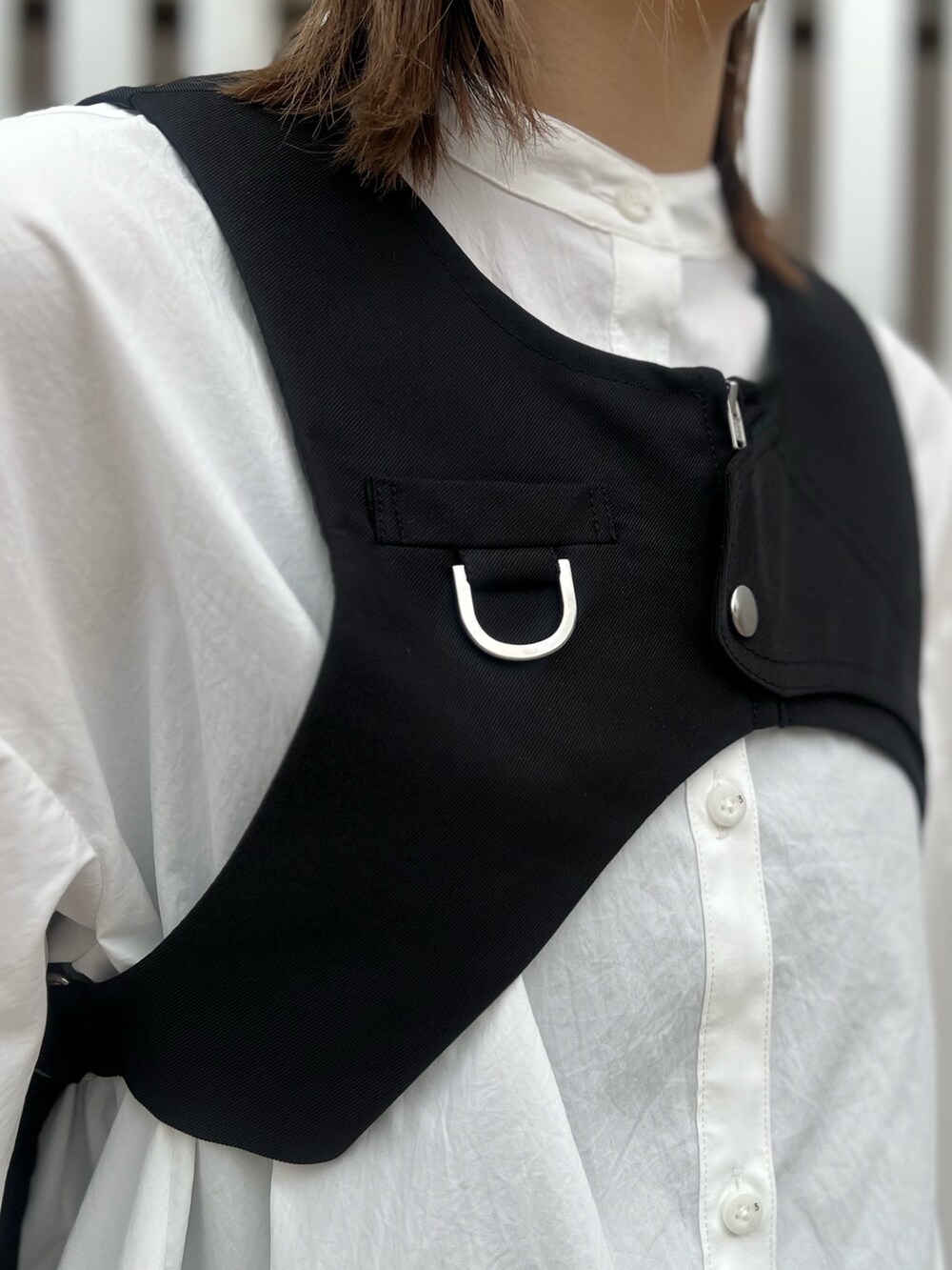 ホワイト系のシャツ/ブラウス、ブラック系のベスト、ブラック系のその他パンツを着用したレディースの冬コーディネートの4枚目の写真