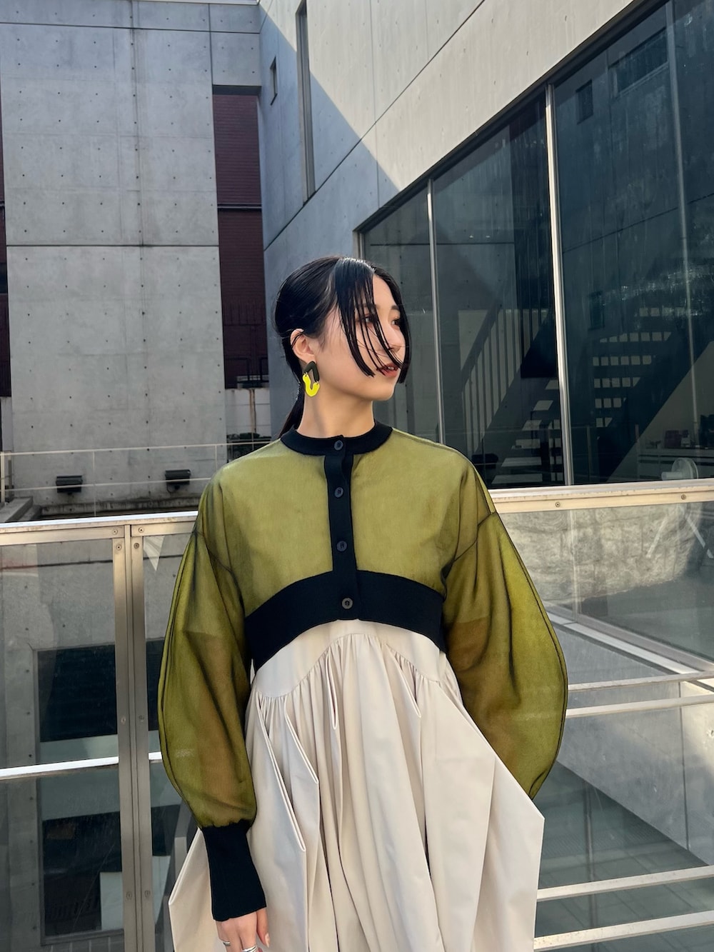 イエロー系のカーディガン/ボレロ、ベージュ系のワンピース、ブラック系のブーツを着用したレディースの冬コーディネートの3枚目の写真