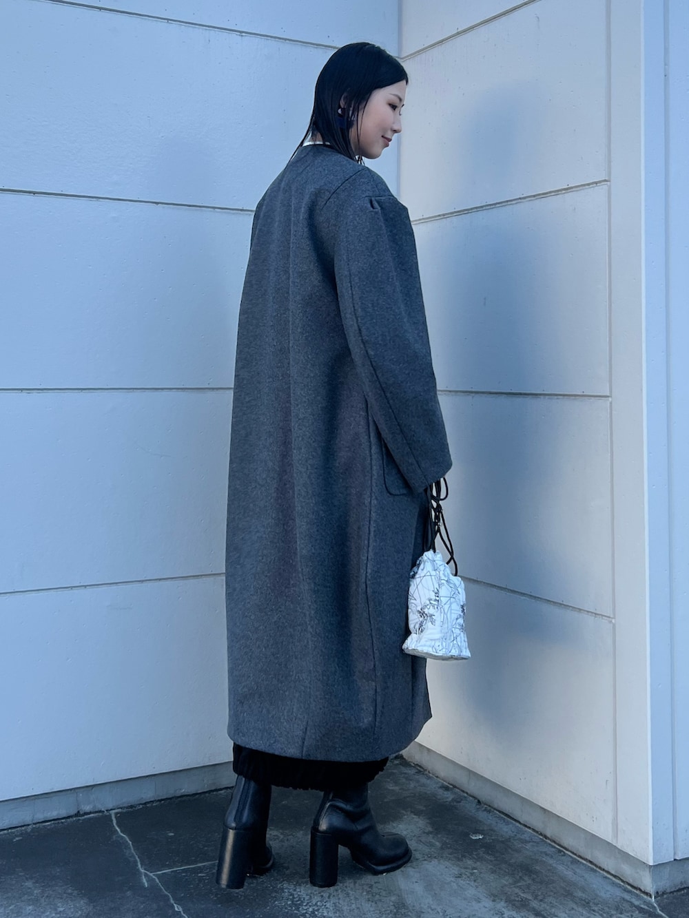 グレー系のその他アウター、ホワイト系のショルダーバッグ、ブラック系のブーツを着用したレディースの冬コーディネートの2枚目の写真