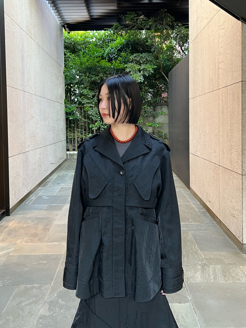 ブラック系のミリタリージャケット、ブラック系のスカート、その他のブーツを着用したレディースの夏コーディネートの3枚目の写真