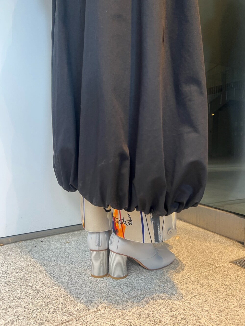 ブラック系のトレンチコート、ベージュ系のその他パンツ、ベージュ系のブーツを着用したレディースの冬コーディネートの8枚目の写真