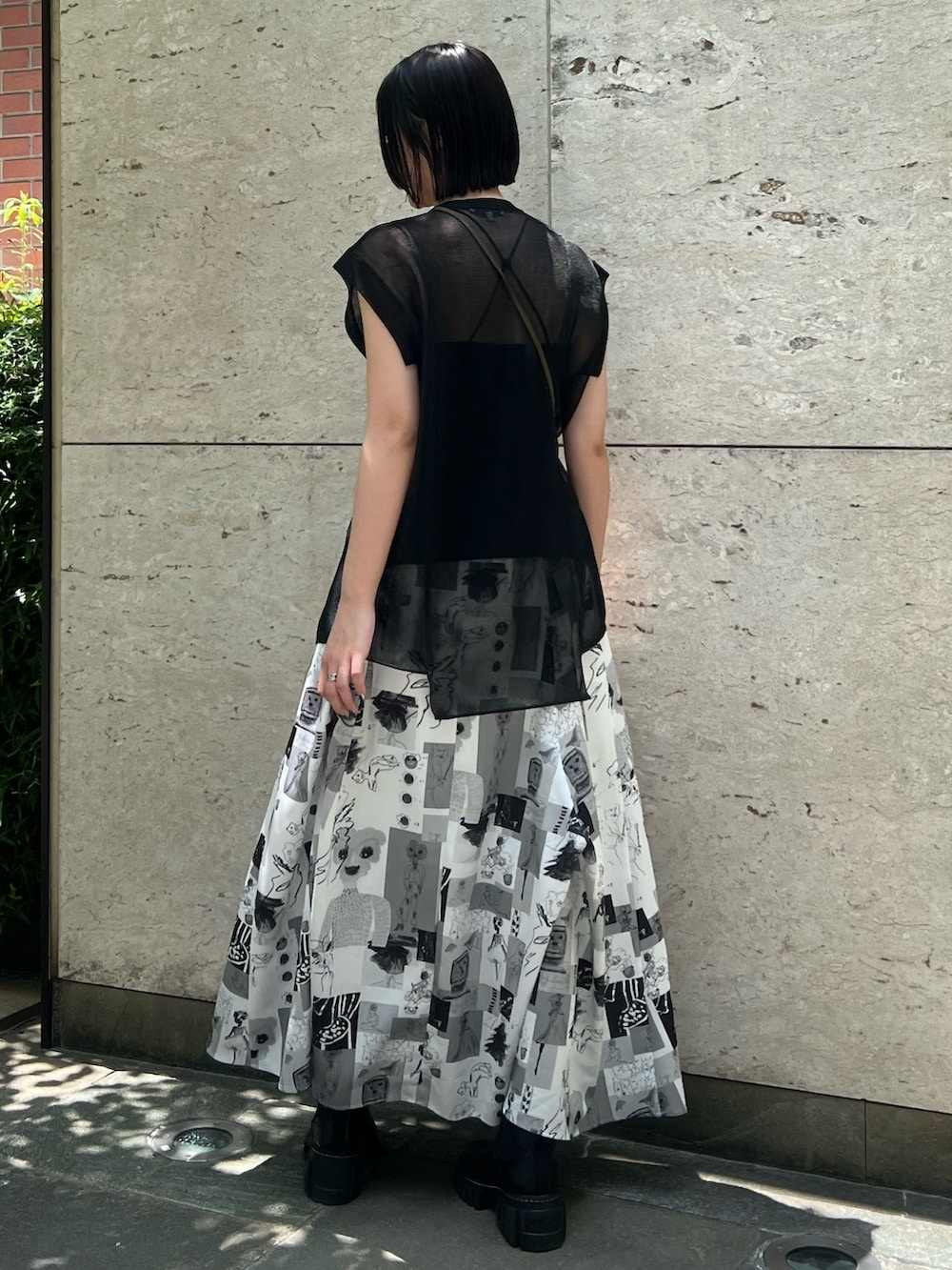 ブラック系のニット/セーター、その他のスカート、ブラック系のショルダーバッグを着用したレディースの夏コーディネートの2枚目の写真