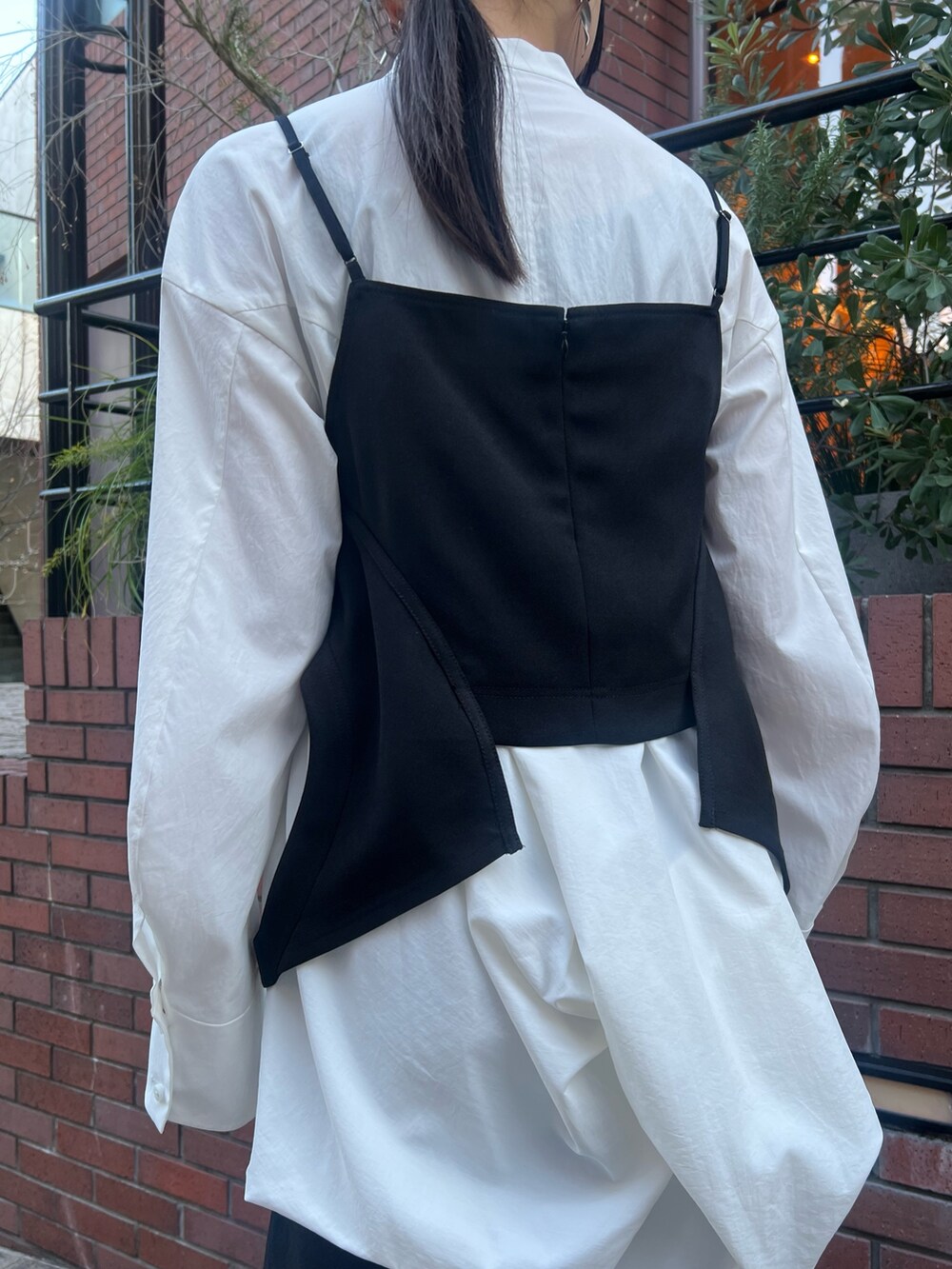 ブラック系のキャミソール、ホワイト系のシャツ/ブラウス、ブラック系のスカートを着用したレディースの冬コーディネートの7枚目の写真