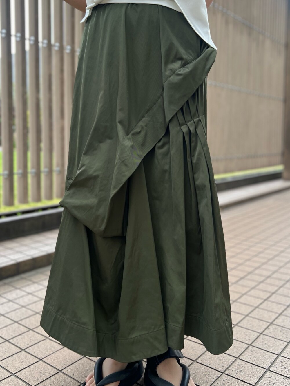 ホワイト系のTシャツ/カットソー、グリーン系のスカート、レッド系のトートバッグを着用したレディースの春コーディネートの7枚目の写真