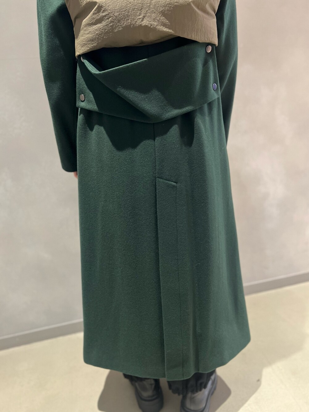 グリーン系のダウンベスト、グリーン系のその他アウター、シルバー系のイヤリングを着用したレディースの秋コーディネートの5枚目の写真