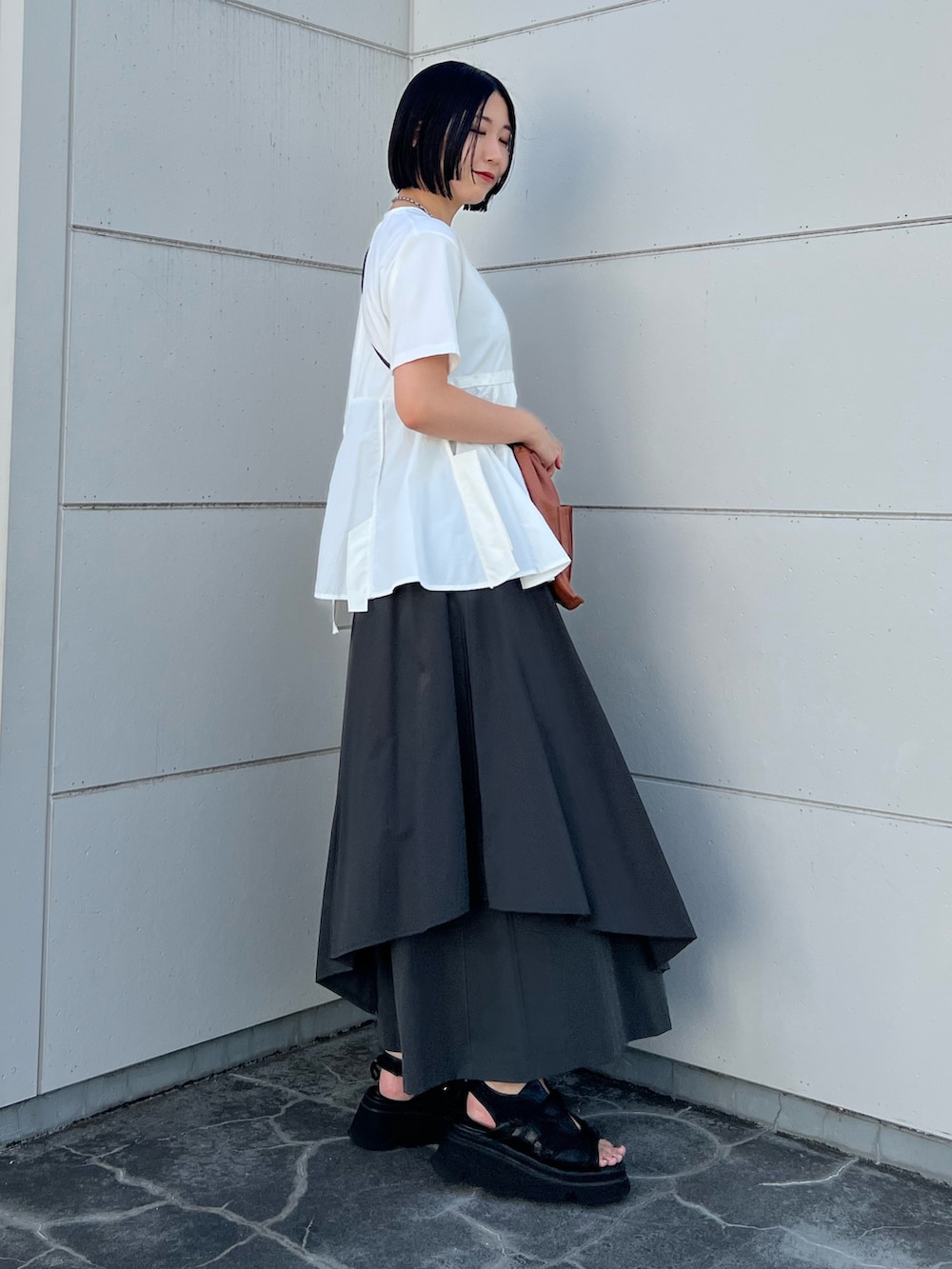 ホワイト系のTシャツ/カットソー、グレー系のその他パンツ、ブラック系のサンダルを着用したレディースの夏コーディネートの2枚目の写真