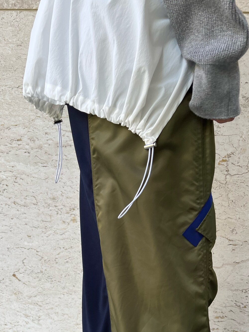 グレー系のニット/セーター、ホワイト系のシャツ/ブラウス、ブルー系のスカートを着用したレディースの秋コーディネートの6枚目の写真