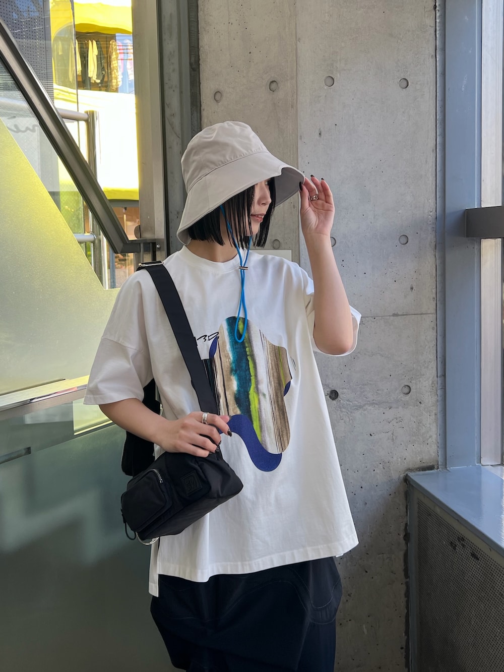 ホワイト系のTシャツ/カットソー、ブラック系のスカート、ブラック系のボディバッグ/ウエストポーチを着用したレディースの春コーディネートの3枚目の写真